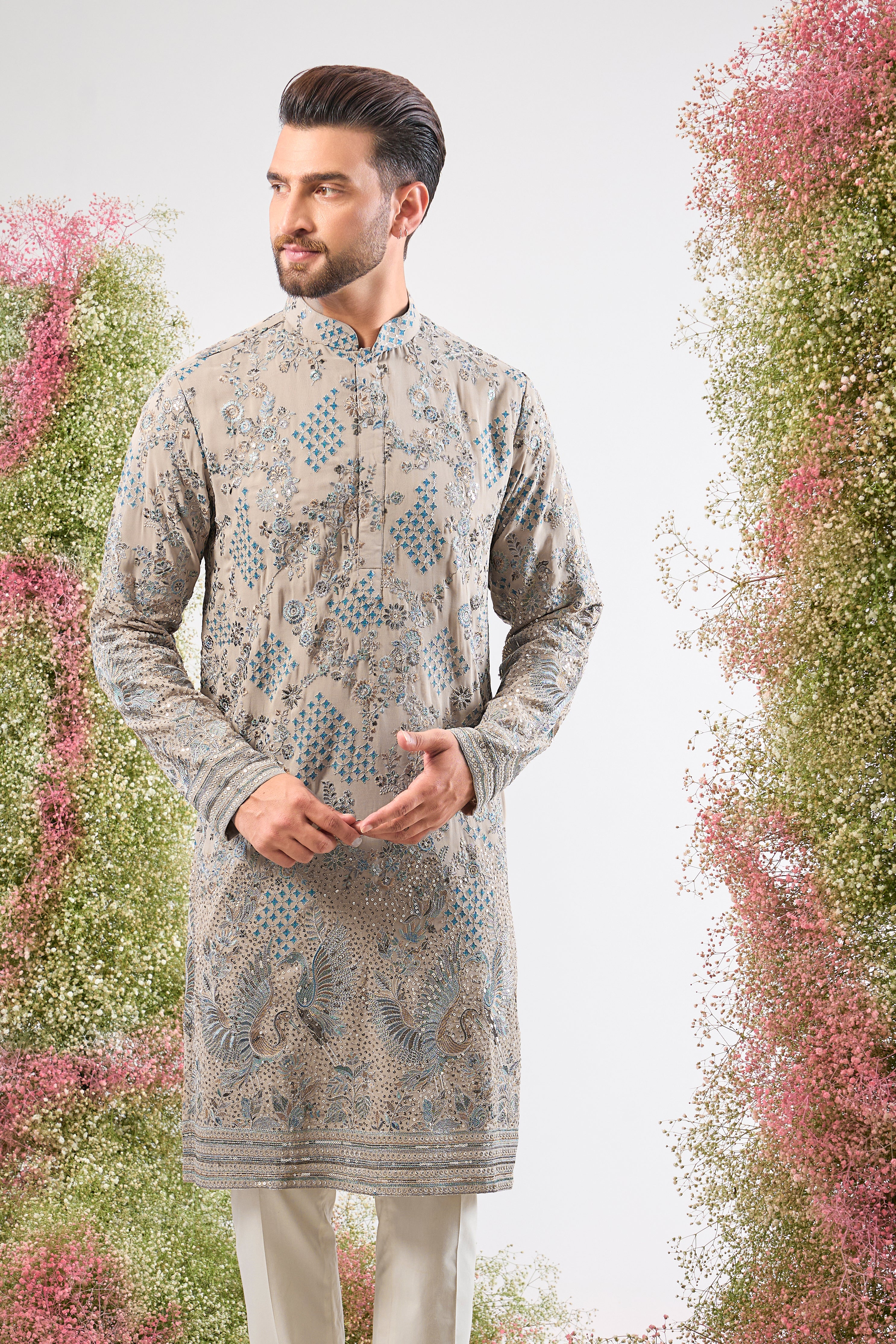 This Nude Coloured Long Kurta showcases magnificent Detailed Flora and Fauna Embroidery, executed with vibrant Multi-thread Work.