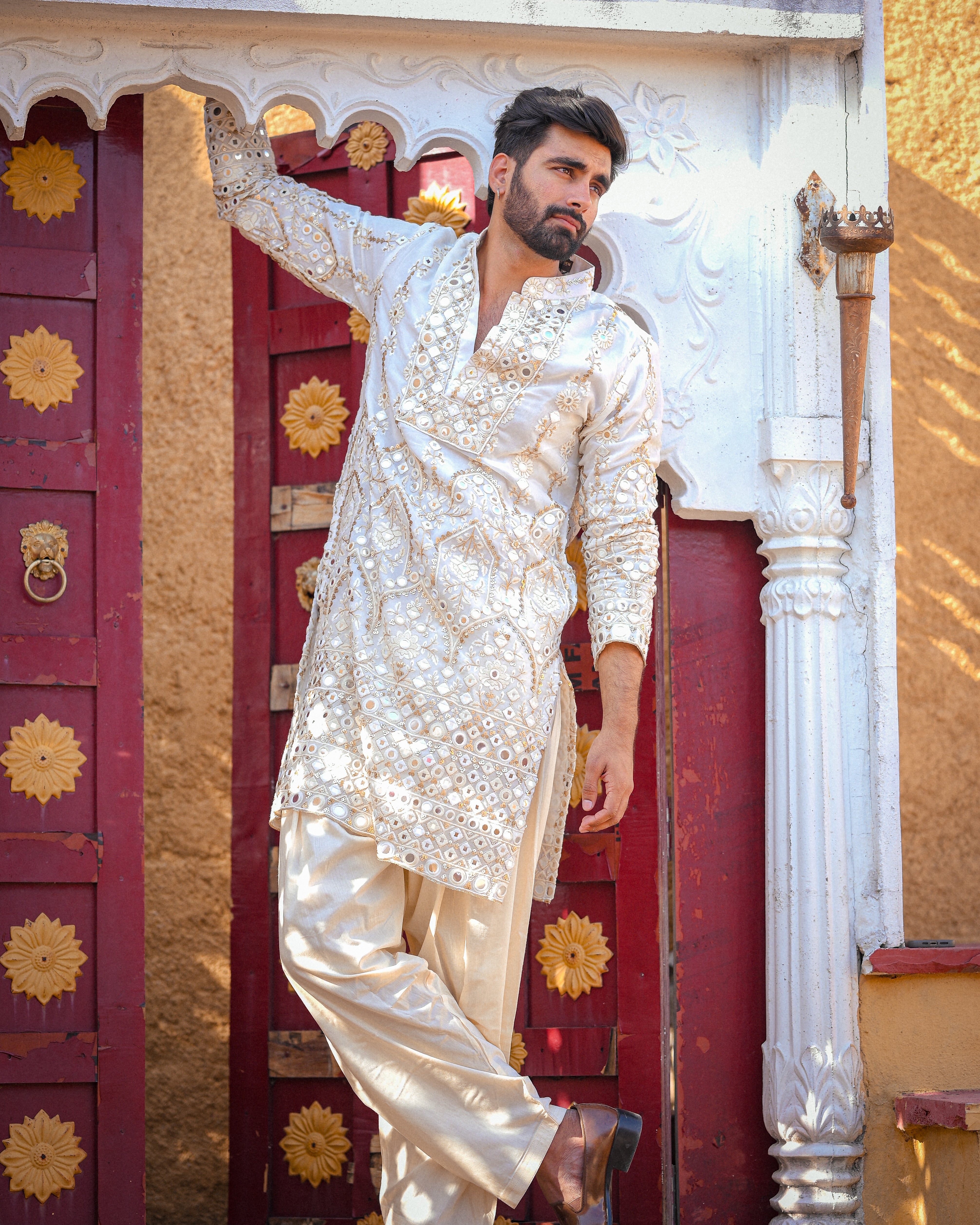 Cream mirror work kurta with detailed neckline and ghera with gold zari highlighting.