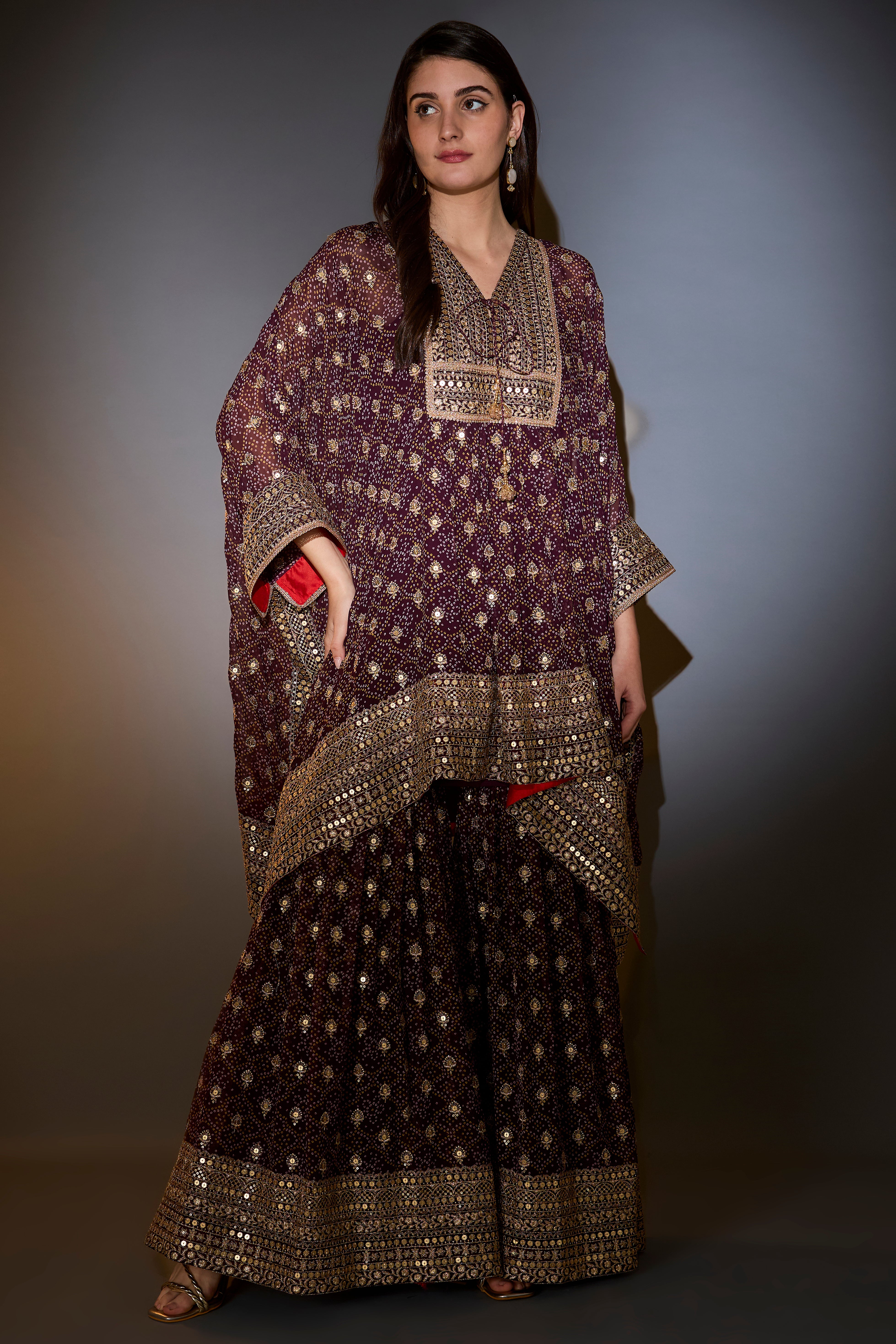 Wine kaftan with sharara with intricate aari and sequins work on the neck, ghera and bottom.