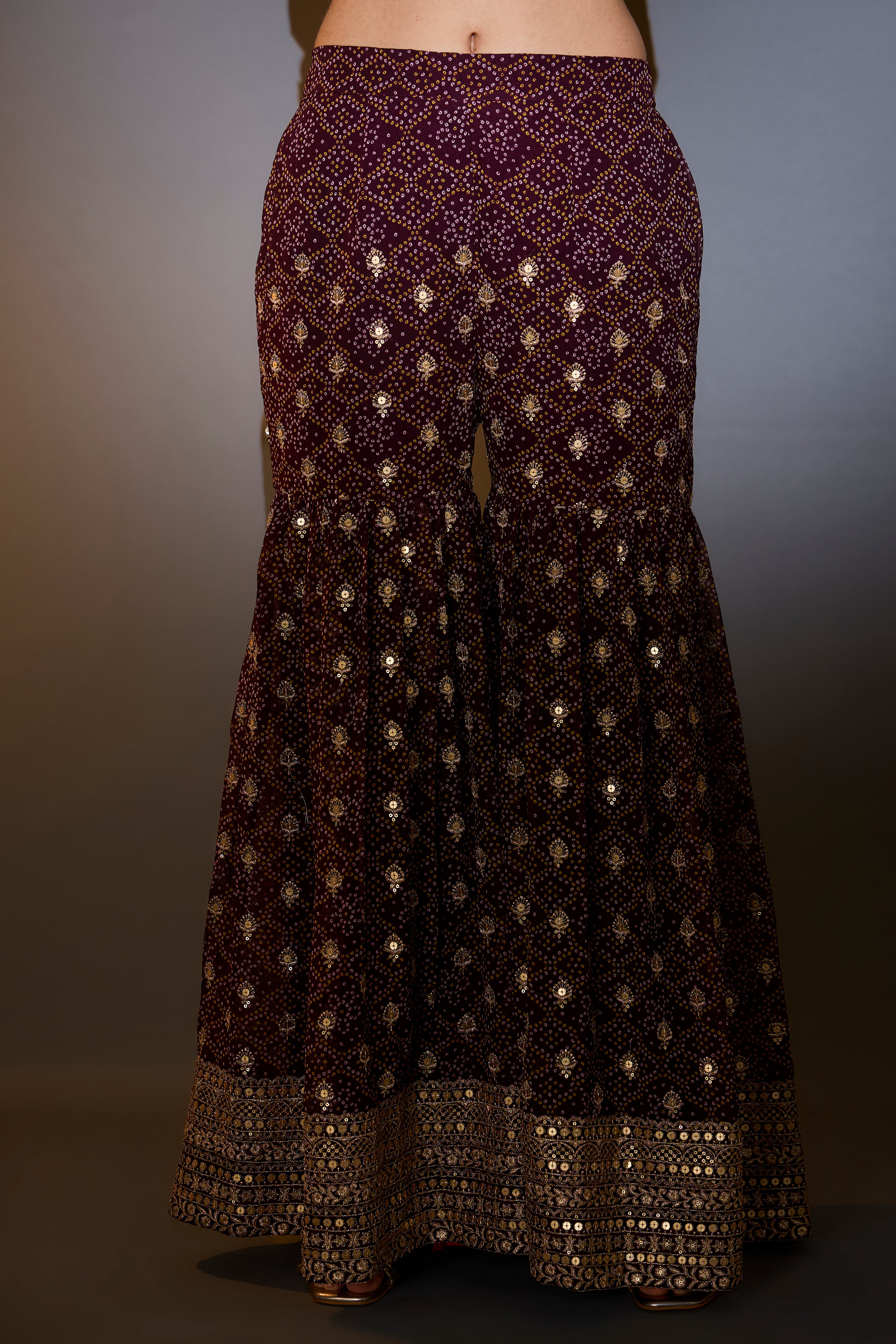 Wine kaftan with sharara with intricate aari and sequins work on the neck, ghera and bottom.