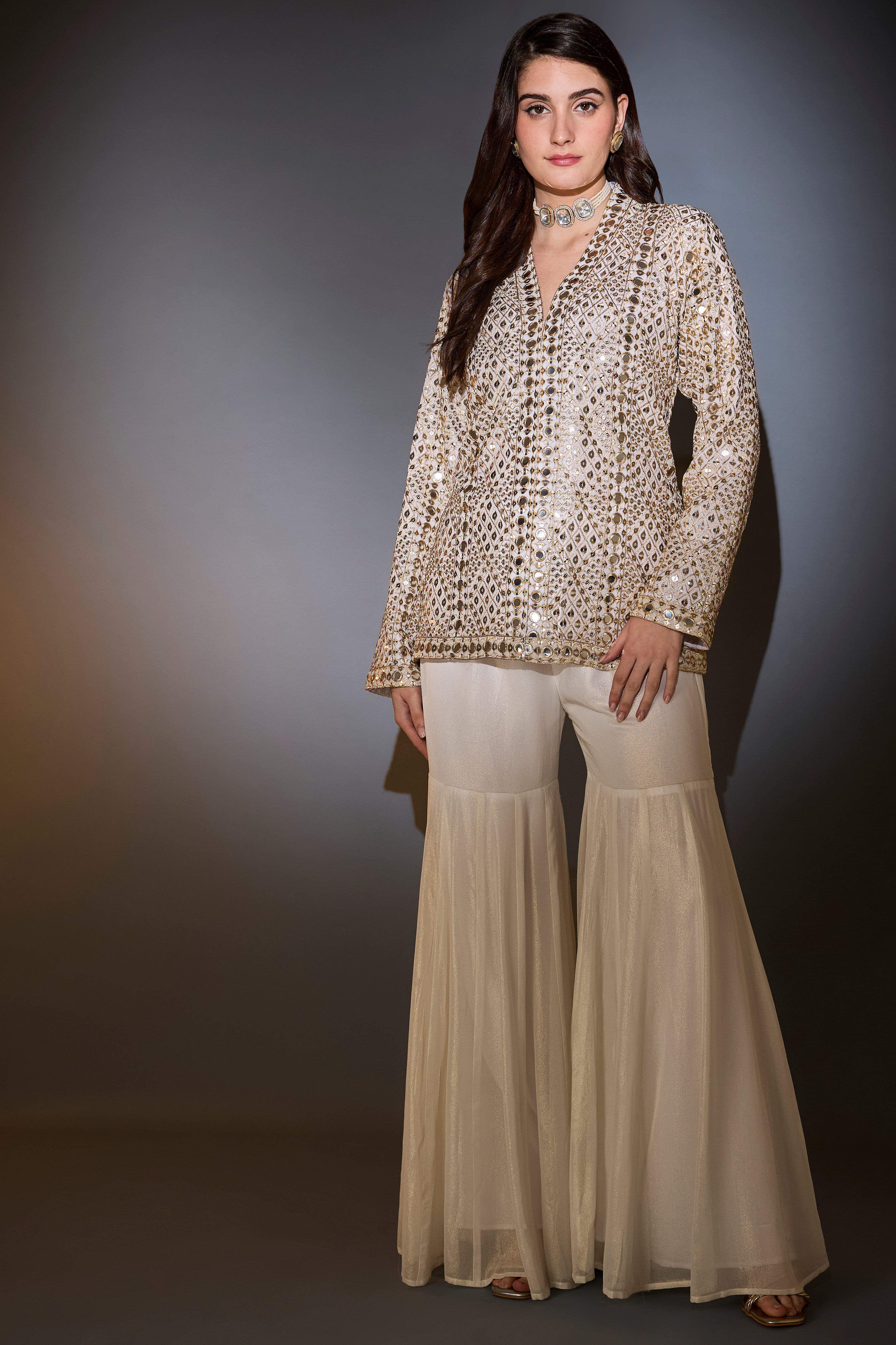 Cream garara set with heavy mirror-work and zari embroidery.