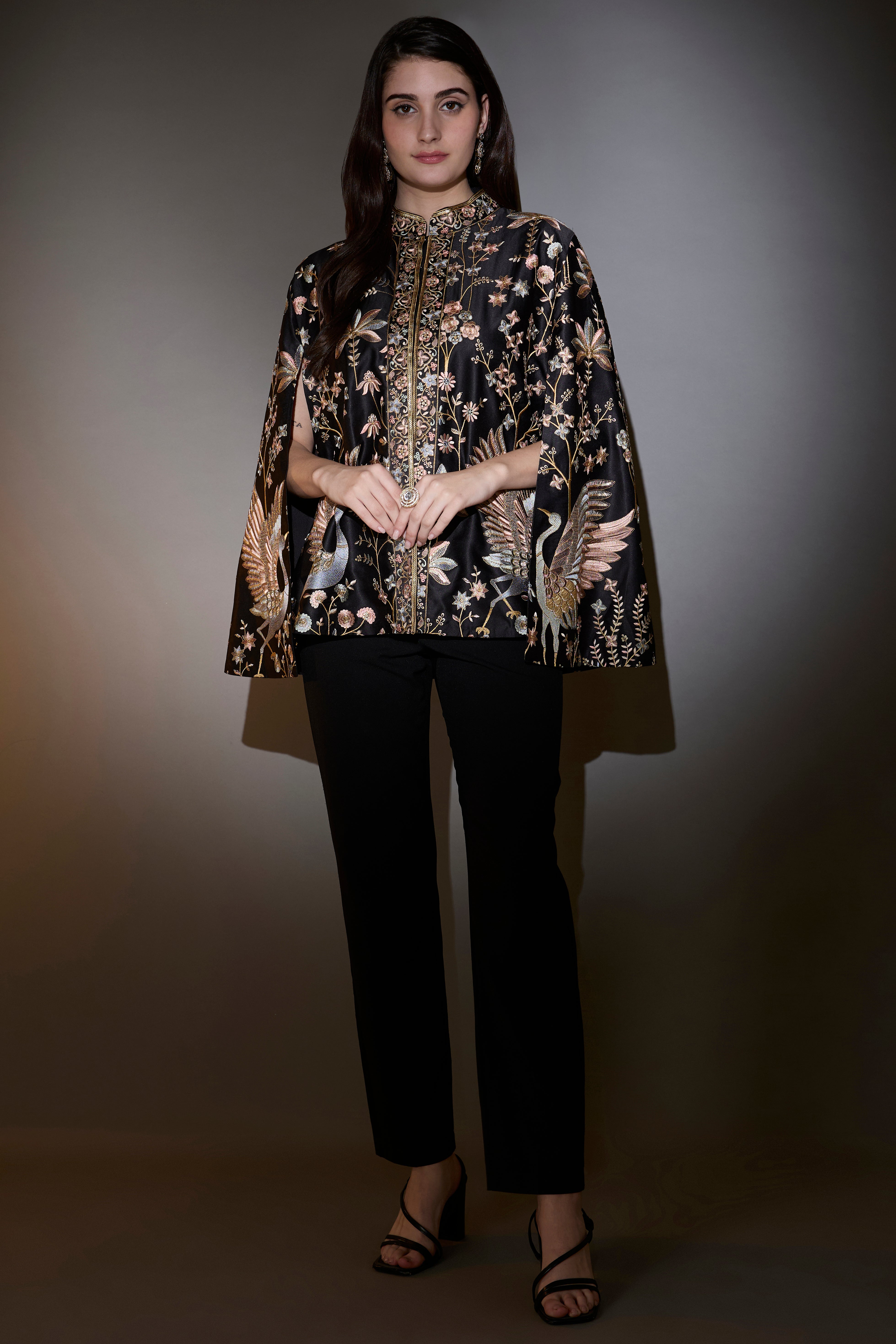 Black cape with intricate multi-thread work, elevated by swan motifs.