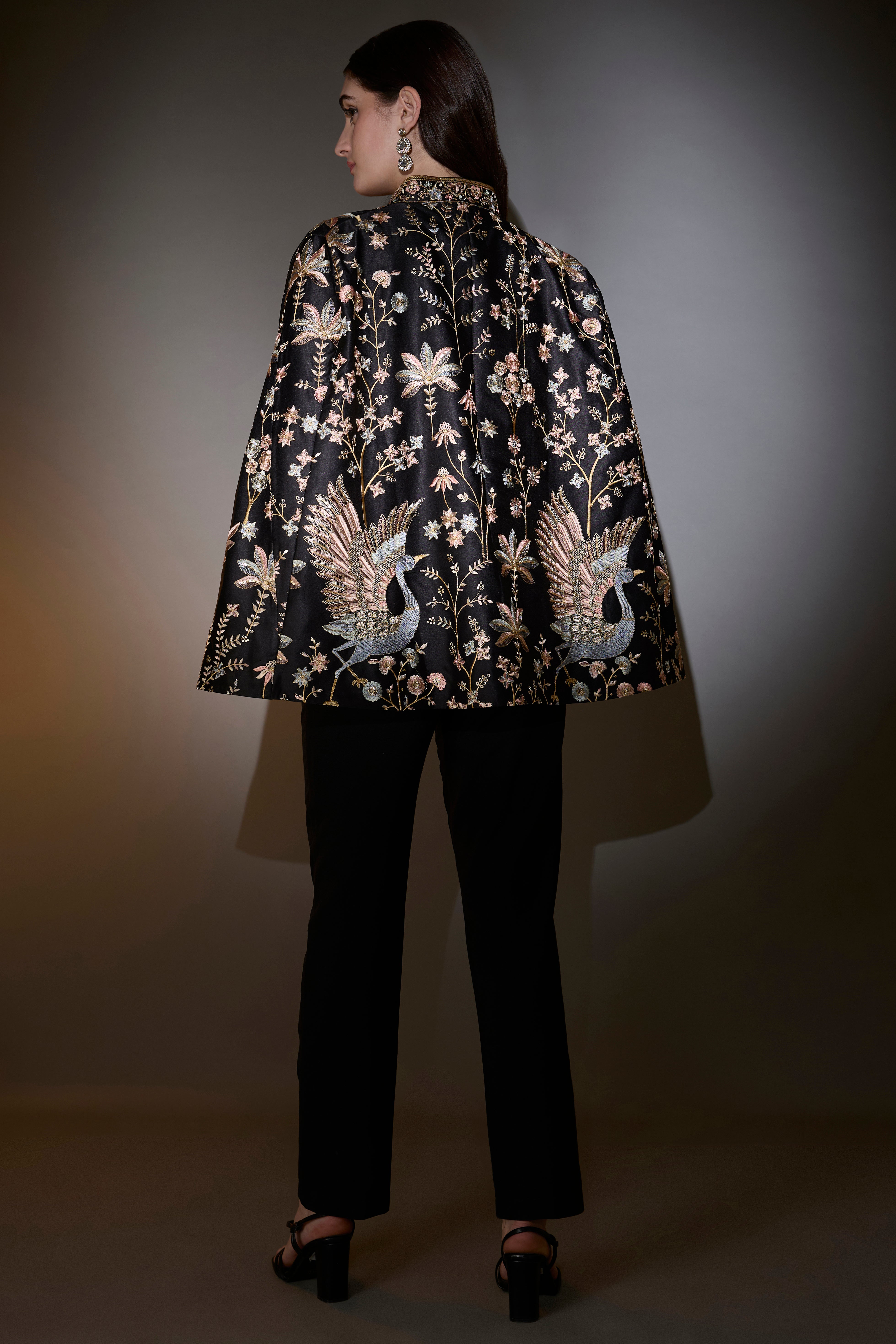 Black cape with intricate multi-thread work, elevated by swan motifs.