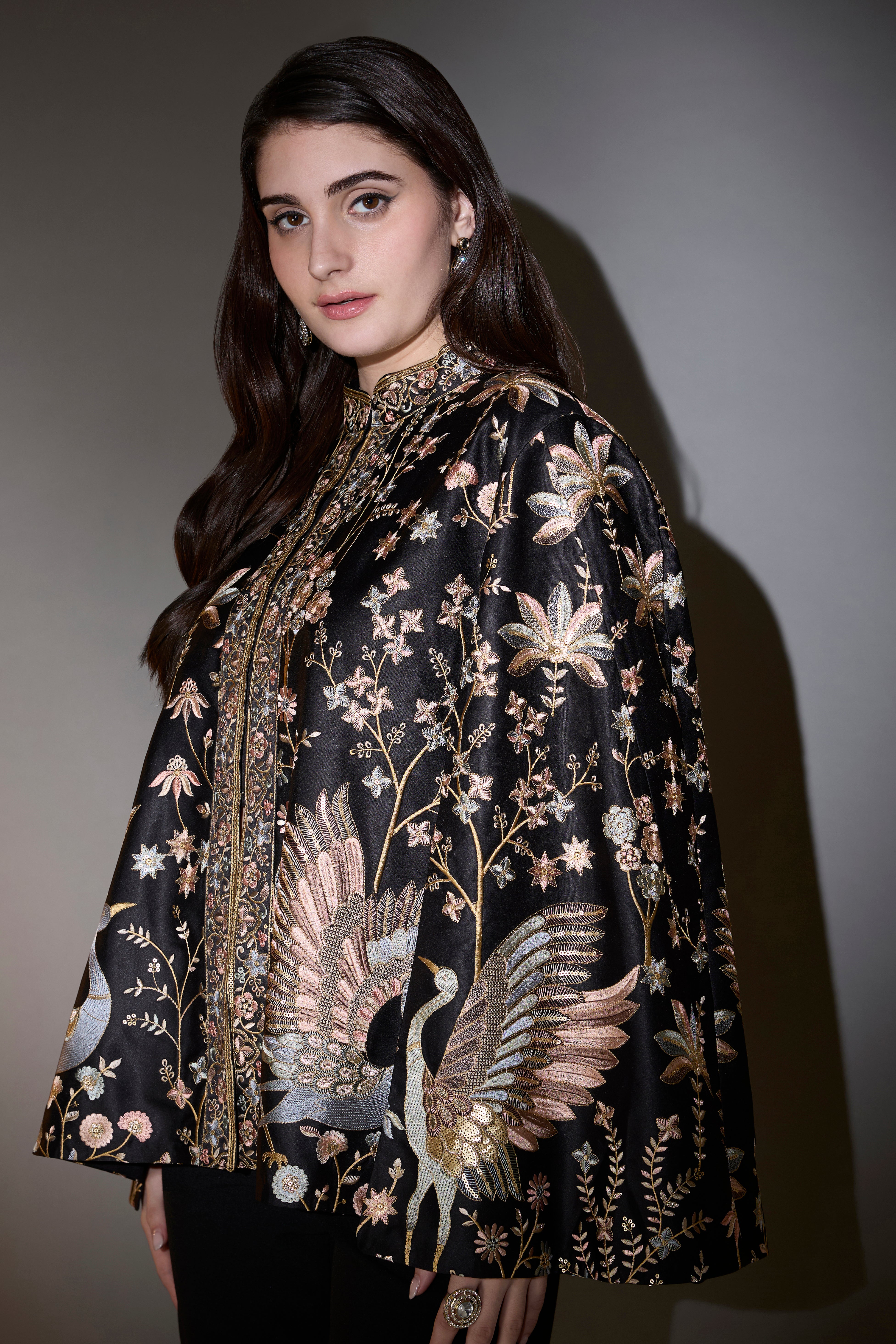 Black cape with intricate multi-thread work, elevated by swan motifs.