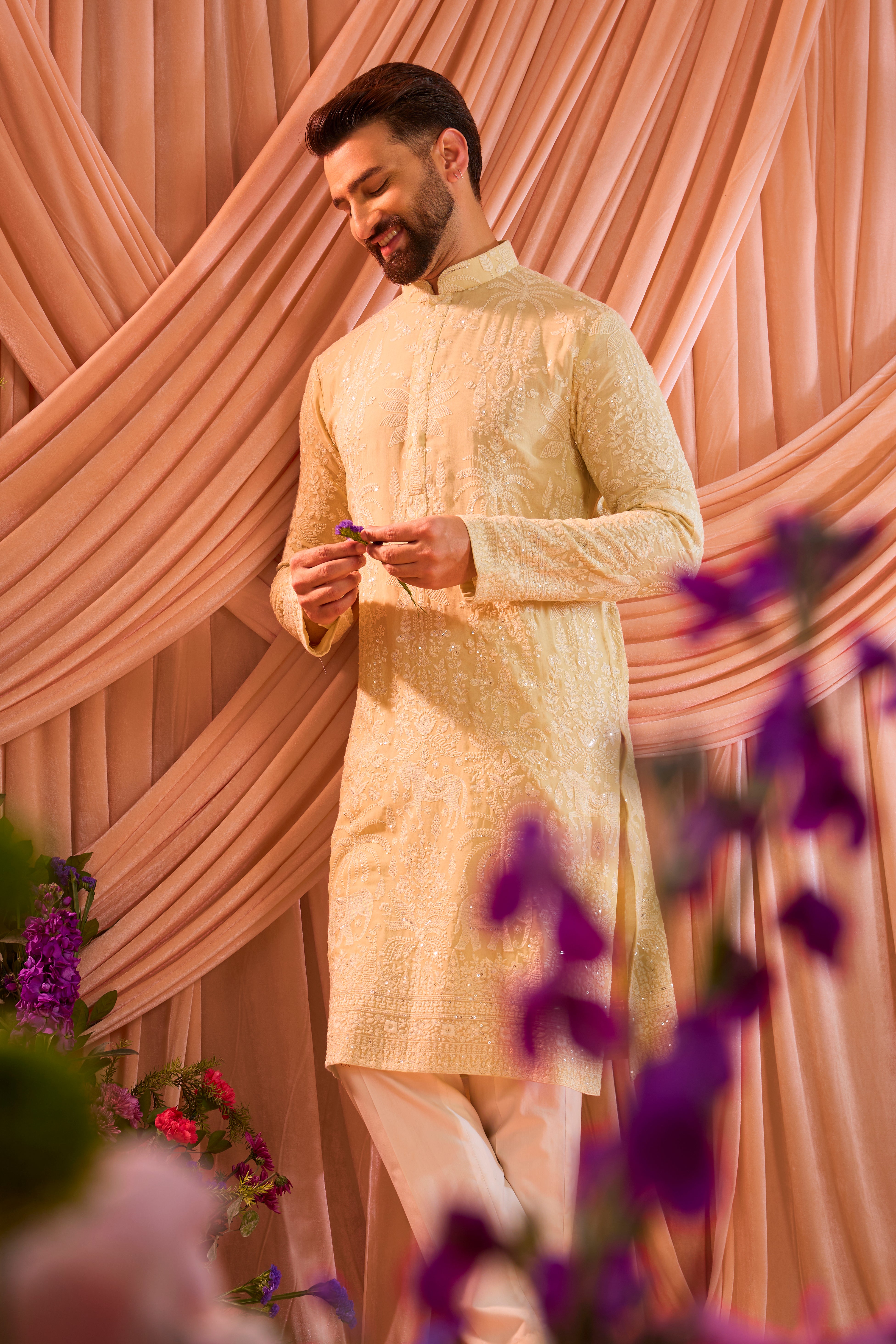 A pastel yellow  kurta illuminated with delicate sequins, brought to life by intricate flora and fauna embroidery.