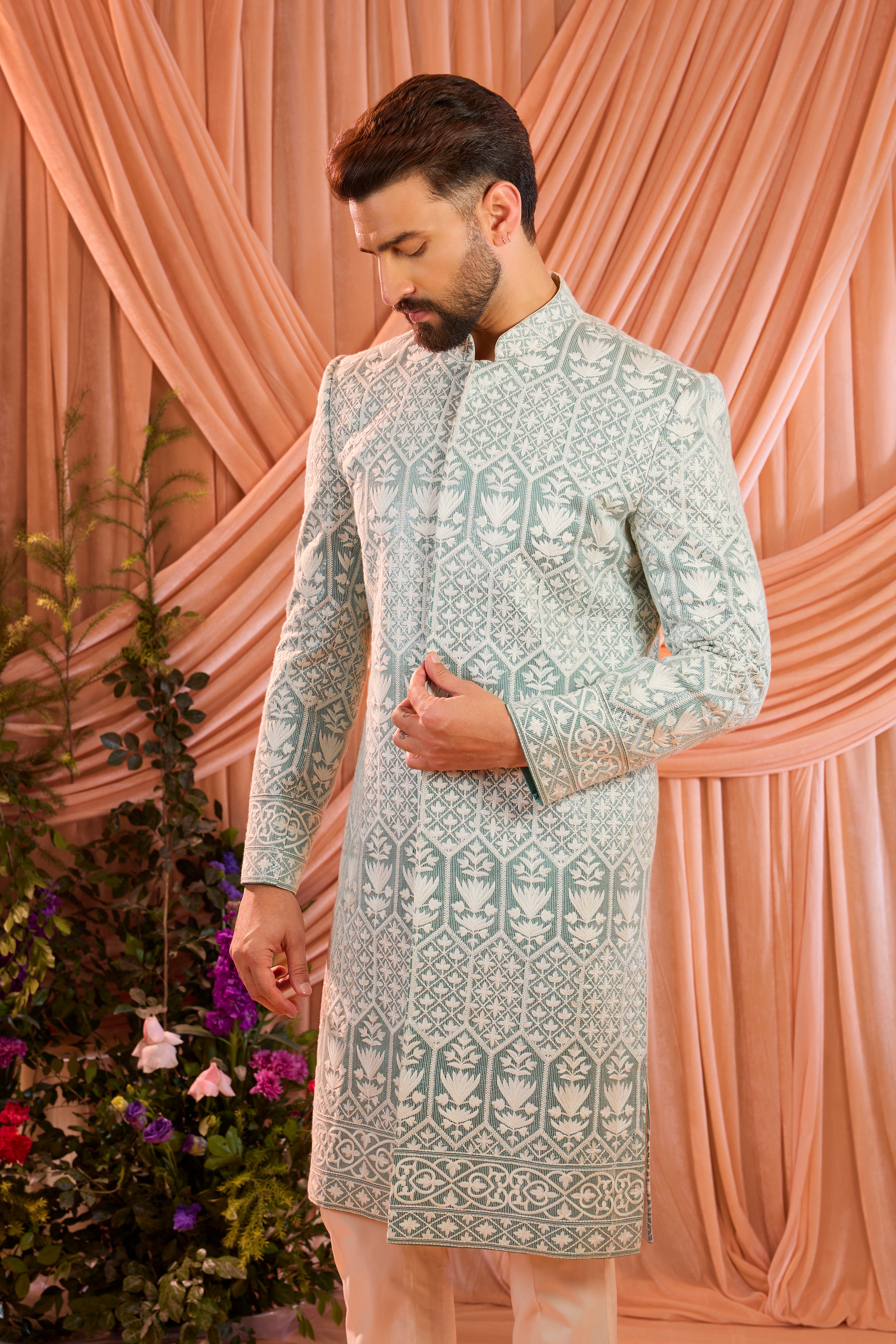 An aqua blue chikankari sherwani distinguished by heavy ivory threadwork and meticulously detailed sequin embellishment.