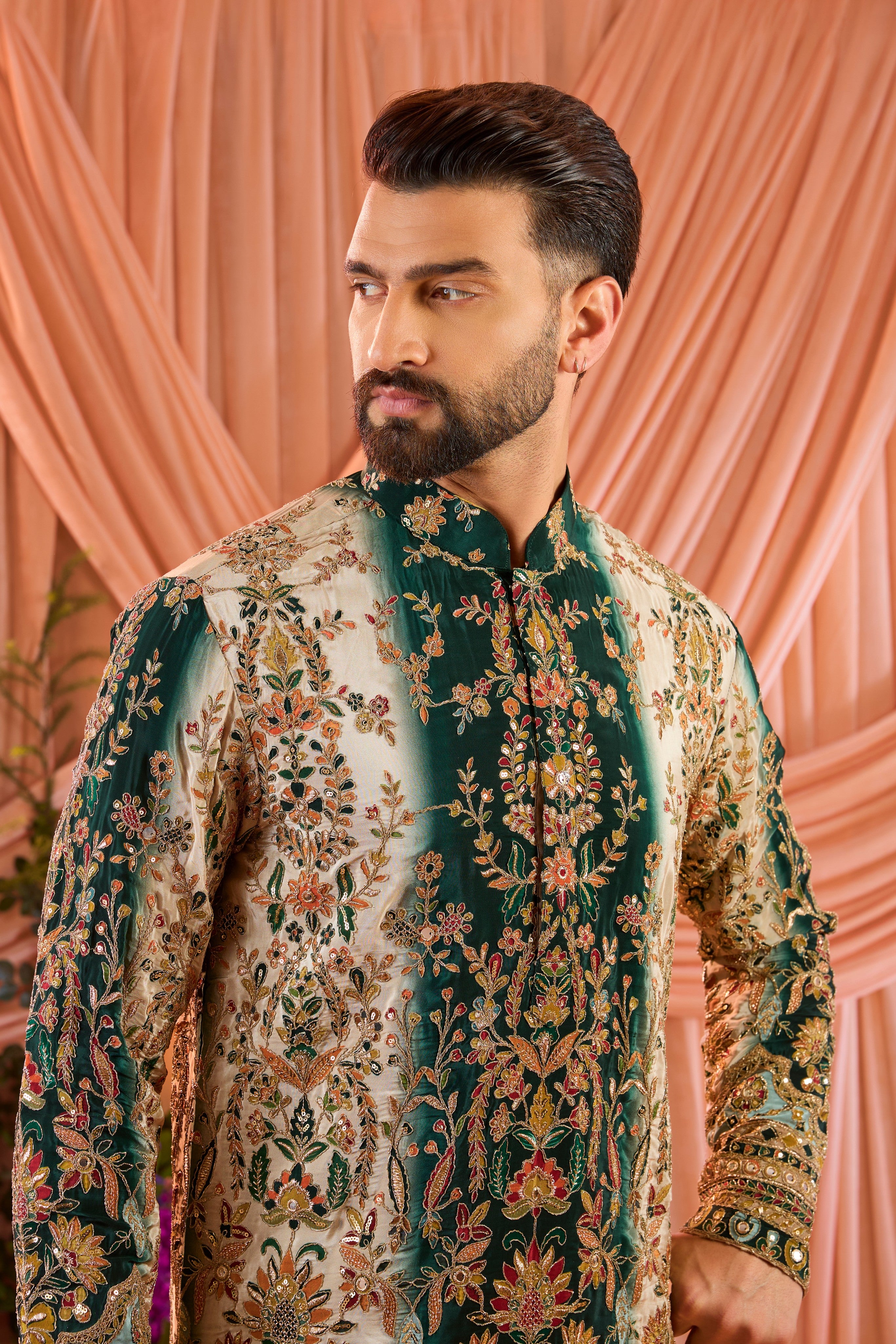 A green and gold short kurta adorned with detailed floral embroidery and shimmering sequin accents