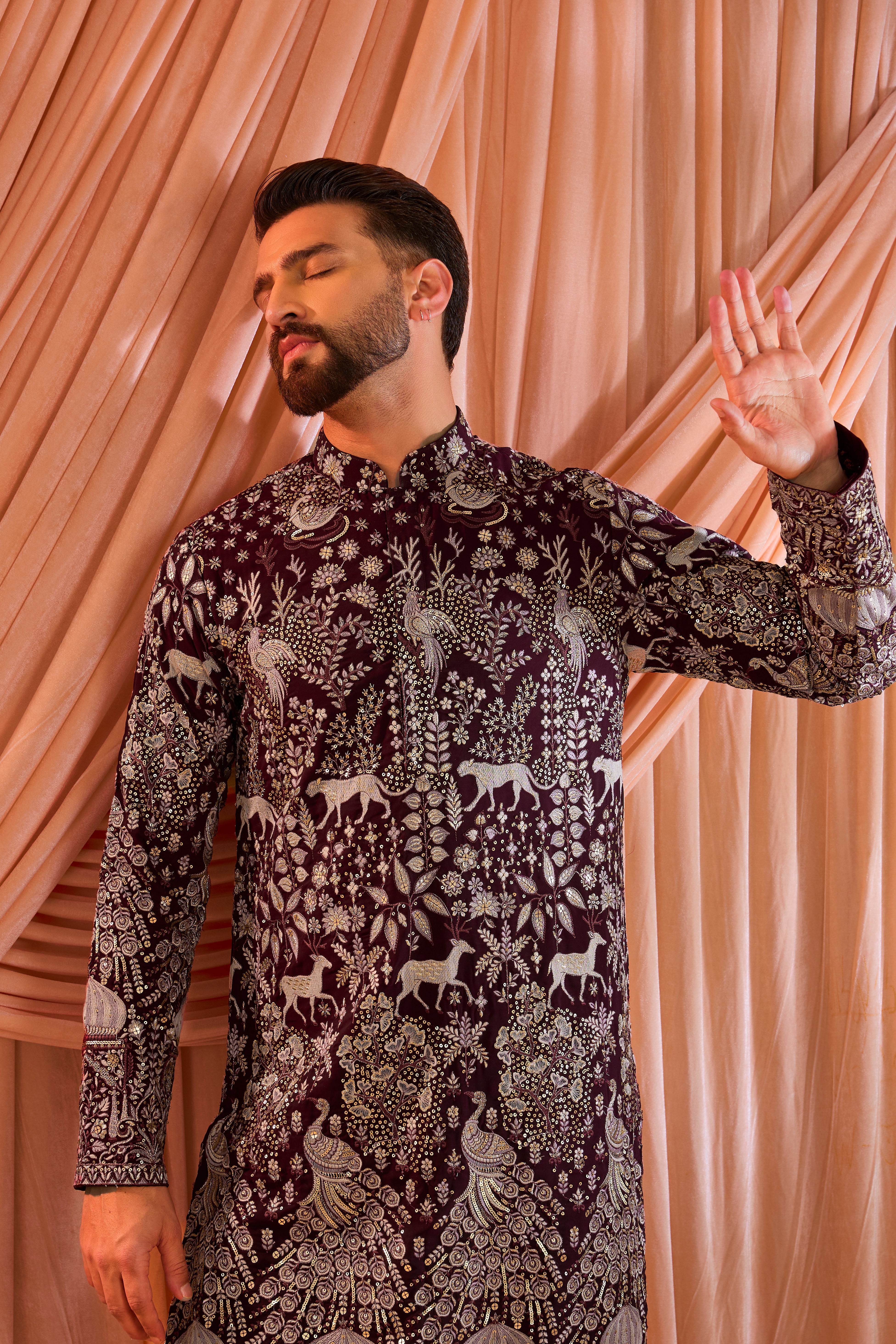 A wine royal-heritage  kurta adorned with detailed flora and fauna motifs and intricate darbar scenes.