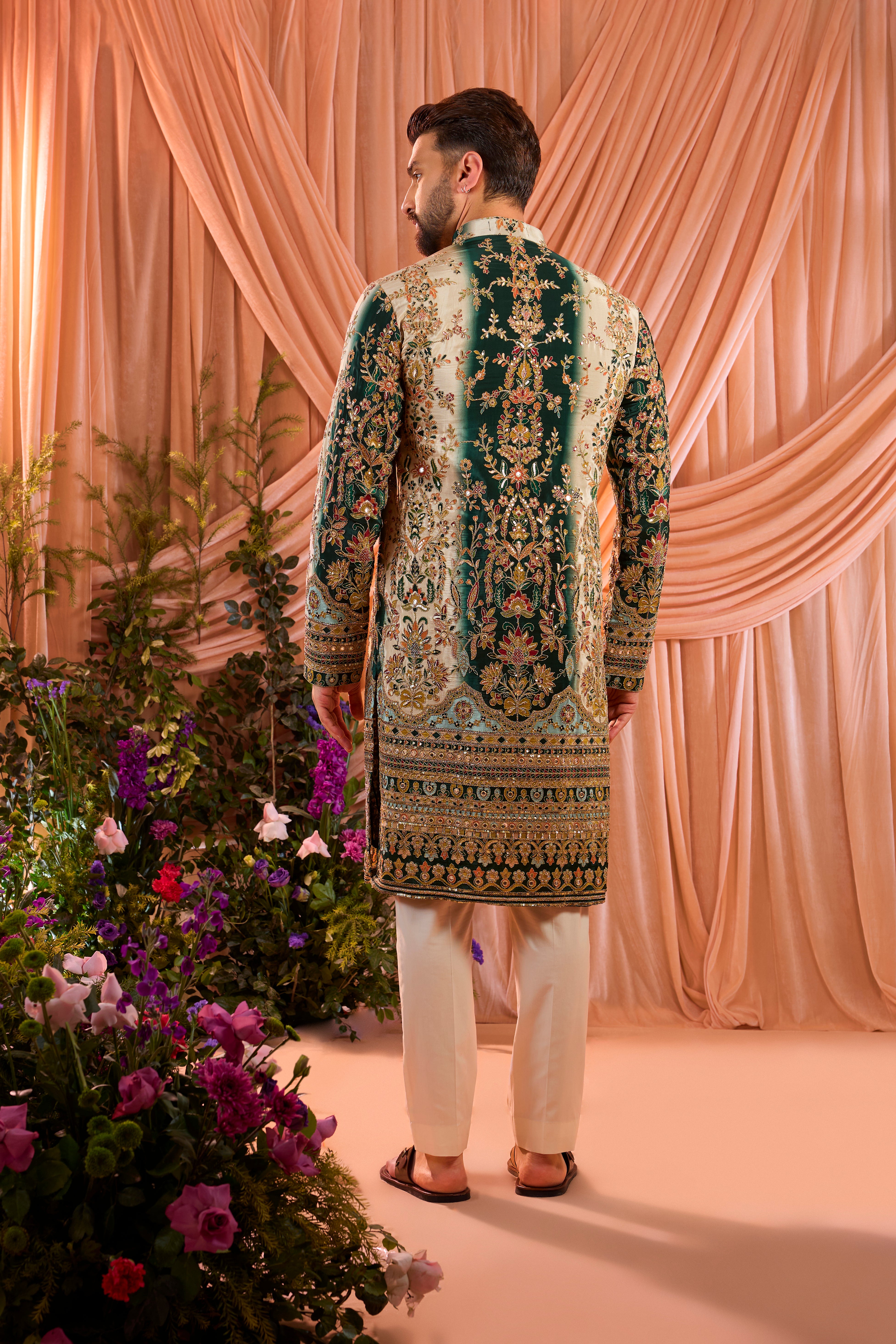A green and gold  kurta adorned with detailed floral embroidery and shimmering sequin accents.