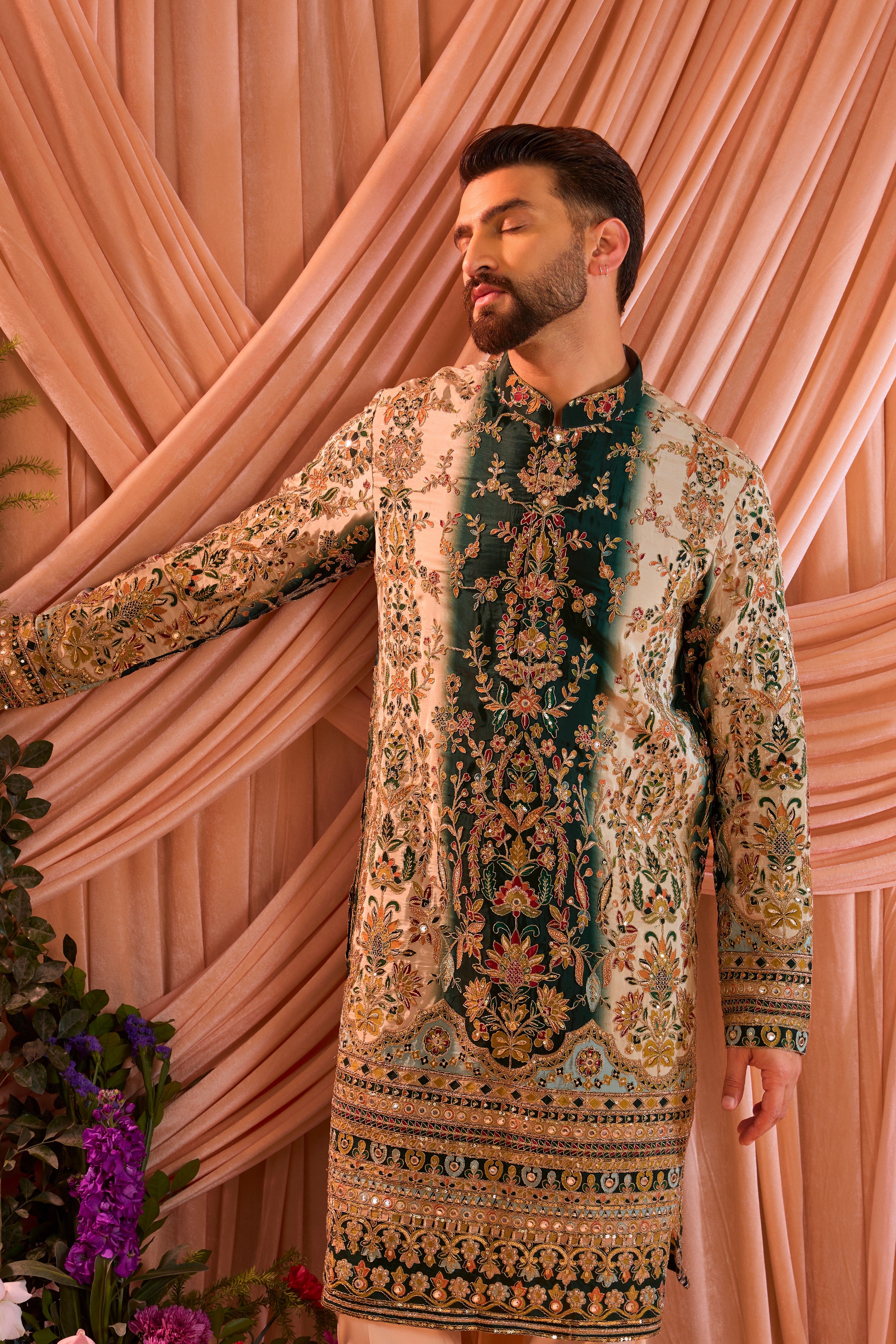 A green and gold  kurta adorned with detailed floral embroidery and shimmering sequin accents.