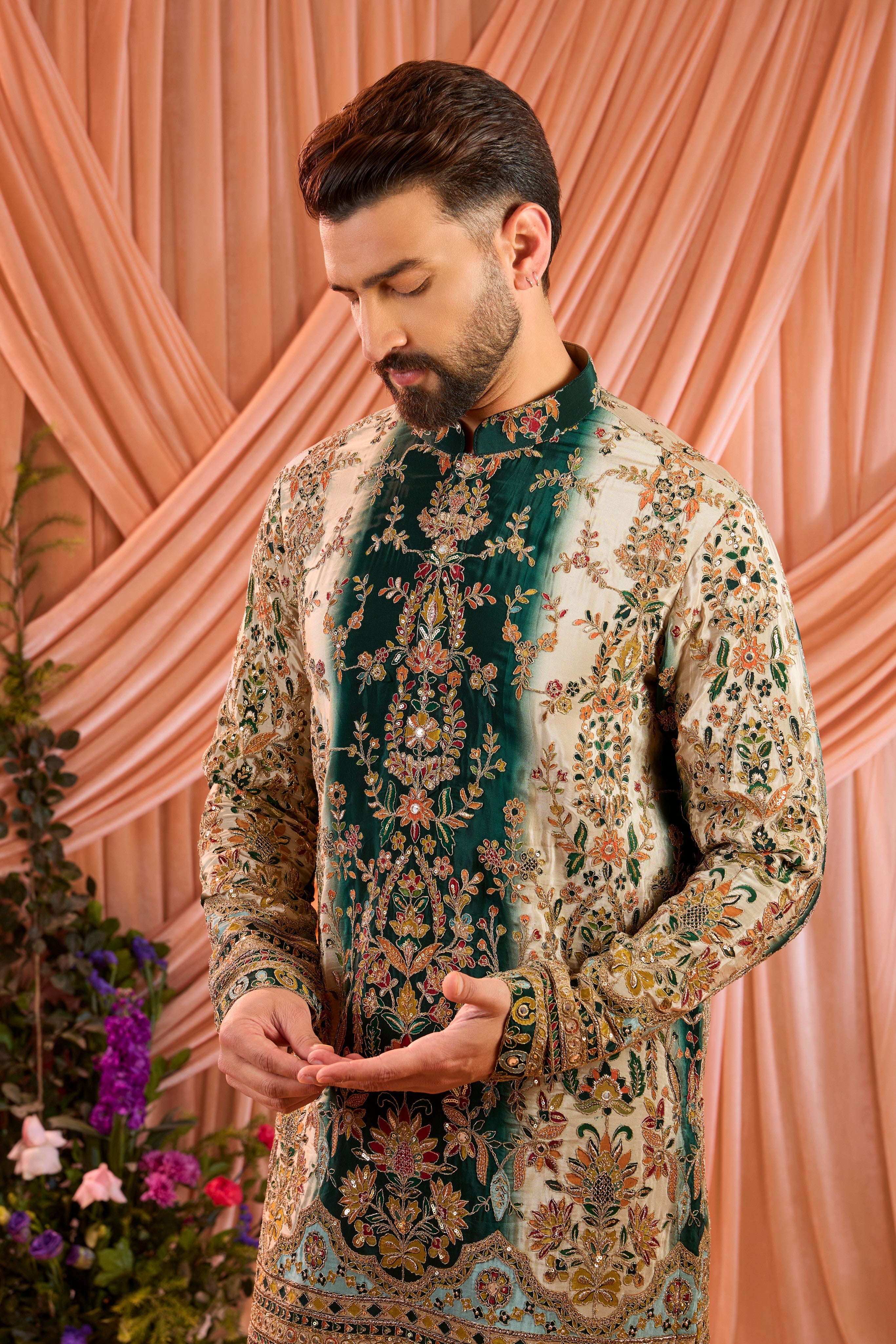A green and gold  kurta adorned with detailed floral embroidery and shimmering sequin accents.