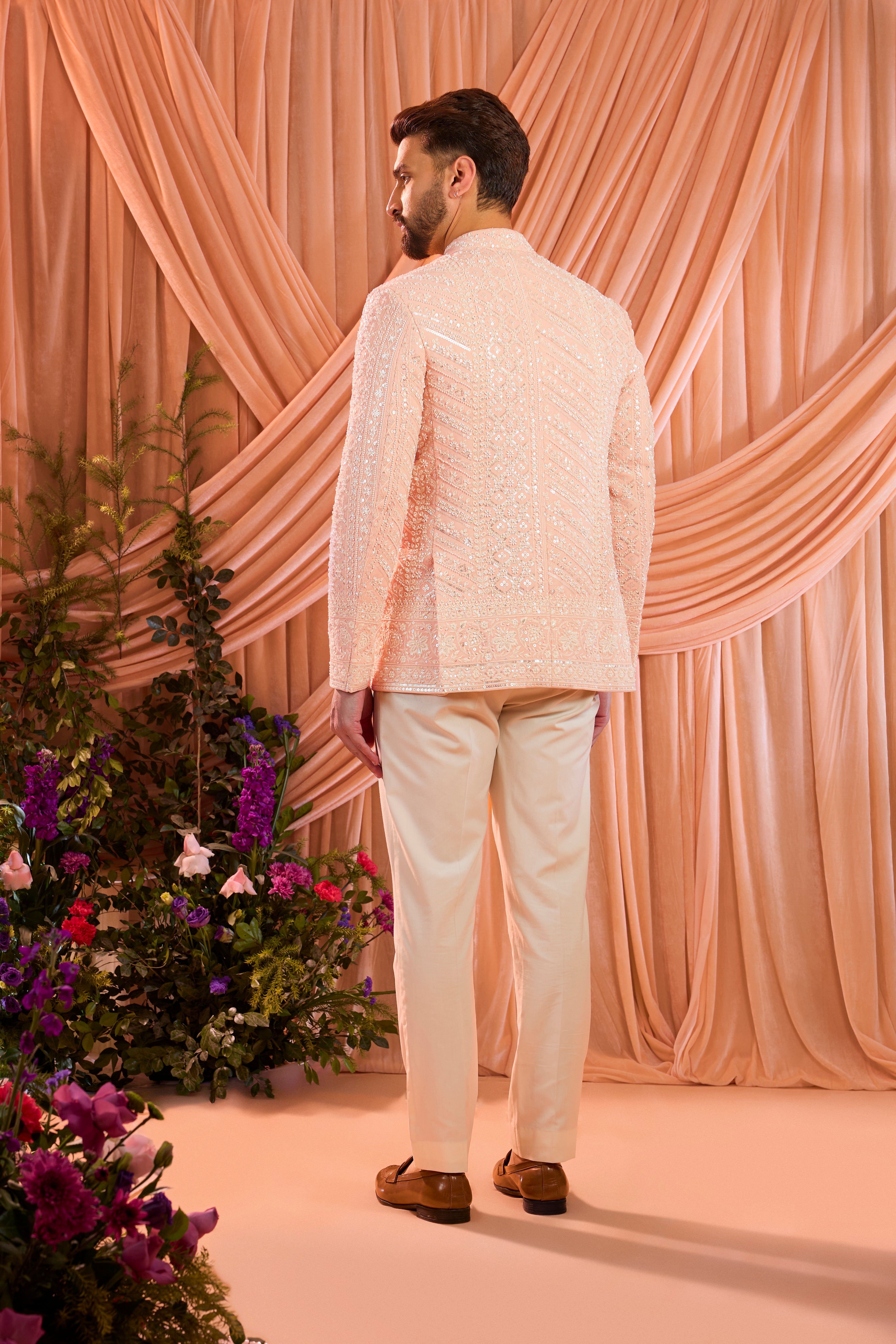 Pink  hand-embroidered formal jacket , exquisitely adorned with intricate ivory cut-dana detailing. The refined shimmer and precision craftsmanship evoke understated opulence and modern royalty.