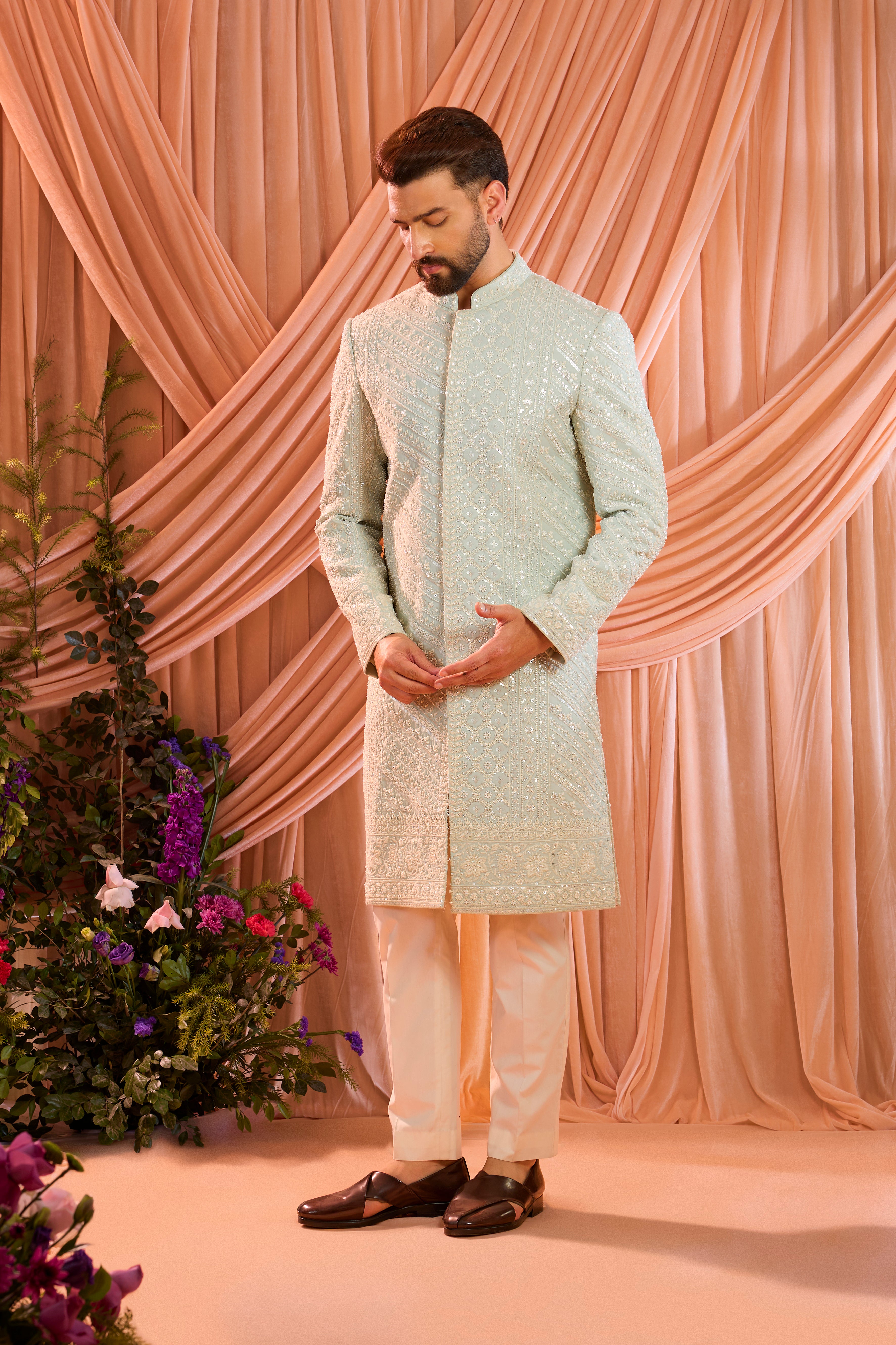 An aqua blue hand-embroidered formal sherwani, exquisitely adorned with intricate ivory cut-dana detailing