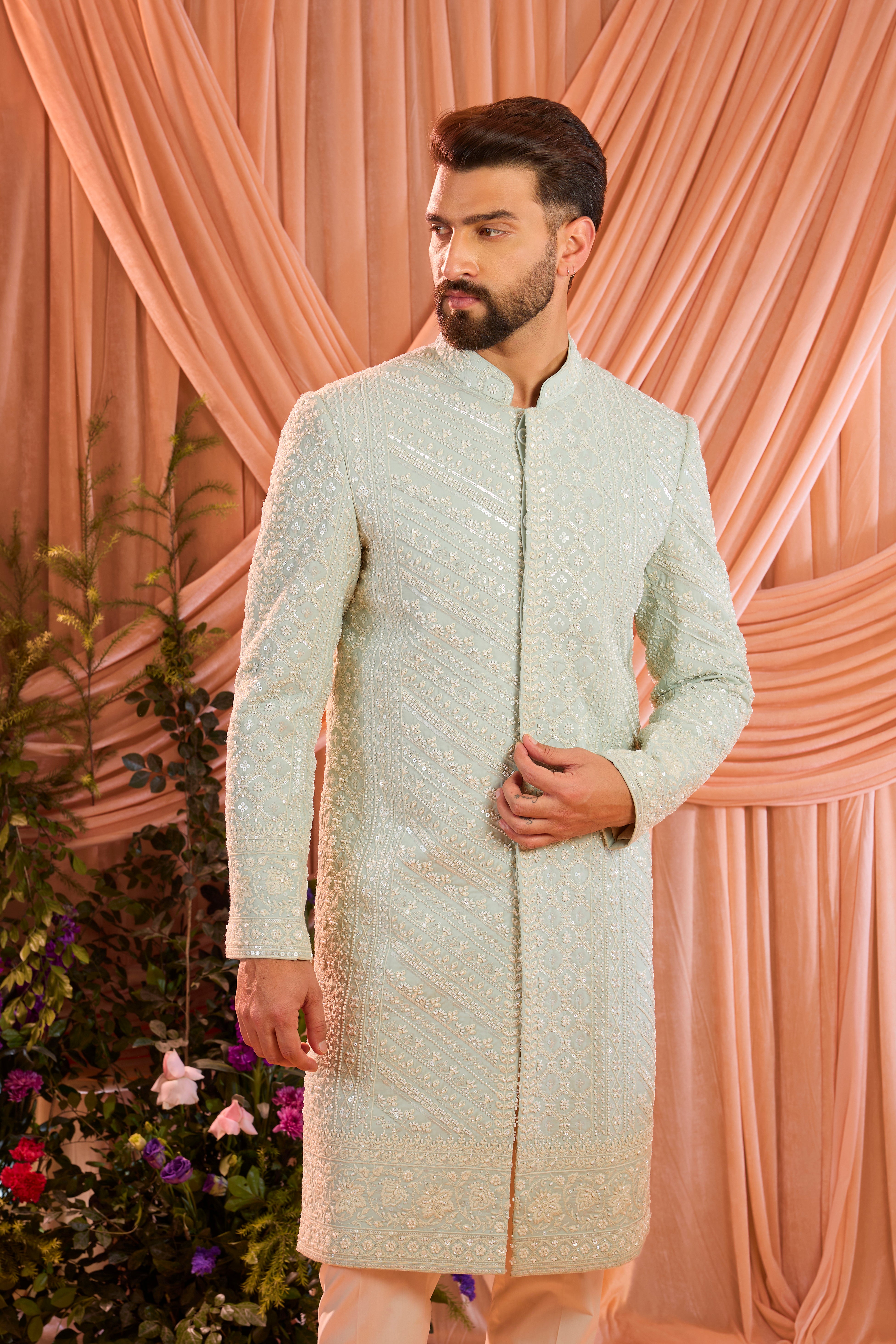 An aqua blue hand-embroidered formal sherwani, exquisitely adorned with intricate ivory cut-dana detailing