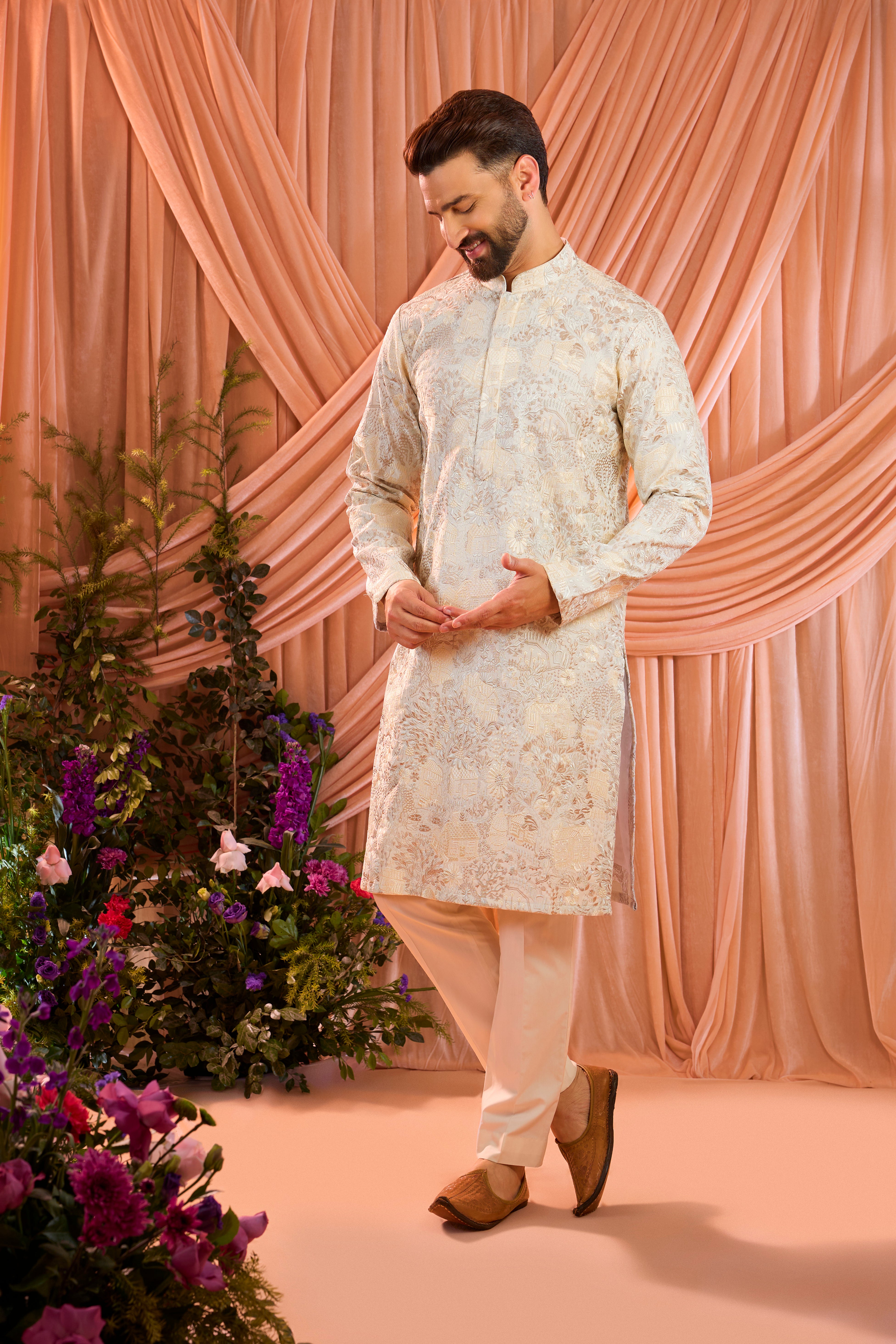A cream tropical chikankari kurta enriched with intricate threadwork and detailed floral motifs, inspired by a vintage homes era.