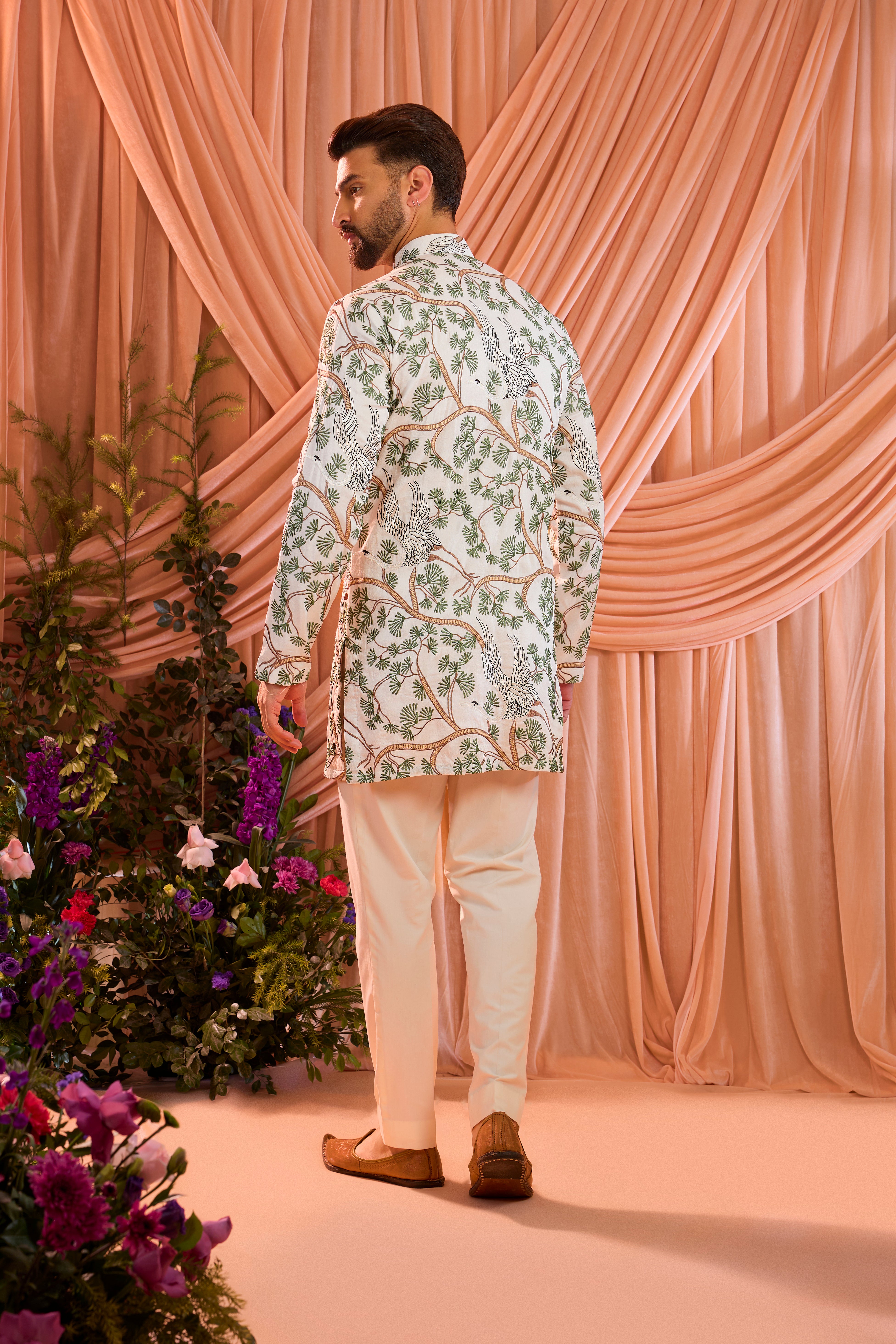 An ivory short kurta featuring a beautifully rendered tropical backdrop, highlighted by serene flamingo motifs.