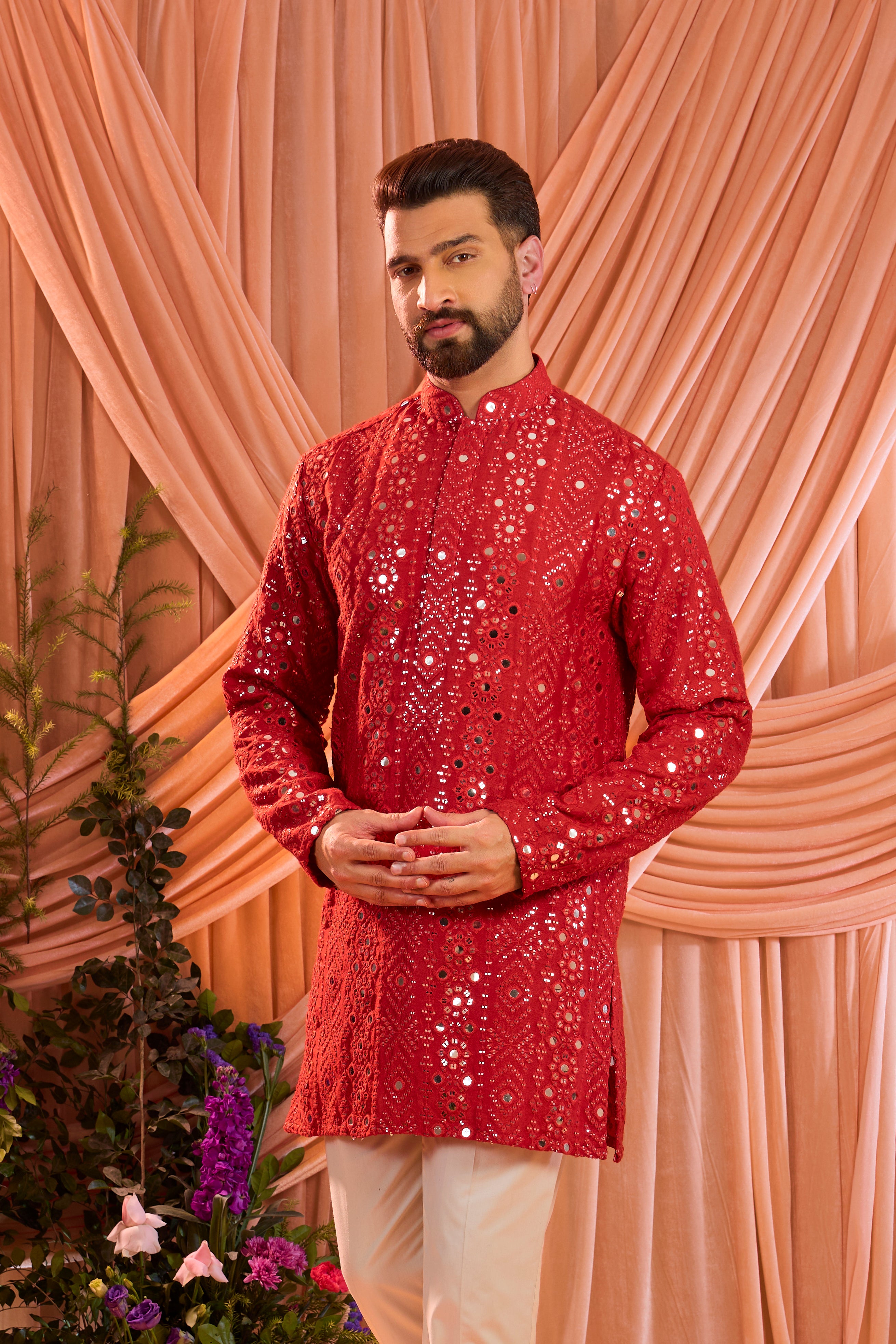 A signature red short kurta featuring mirror-inspired sequin work that recreates the brilliance of traditional mirror craftsmanship.