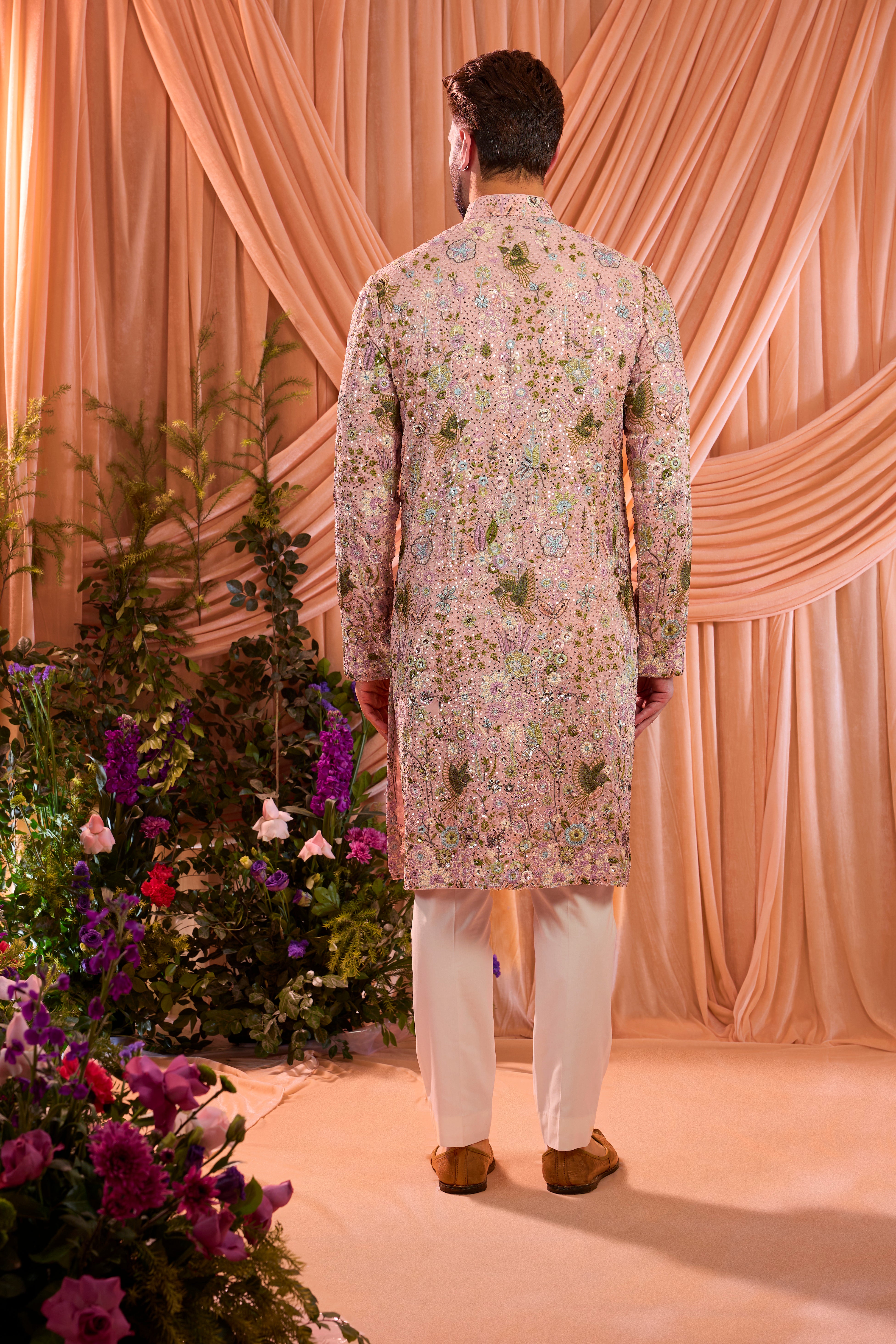 A pink sequined  kurta adorned with detailed flora and fauna motifs, brought to life through intricate multi-thread embroidery.