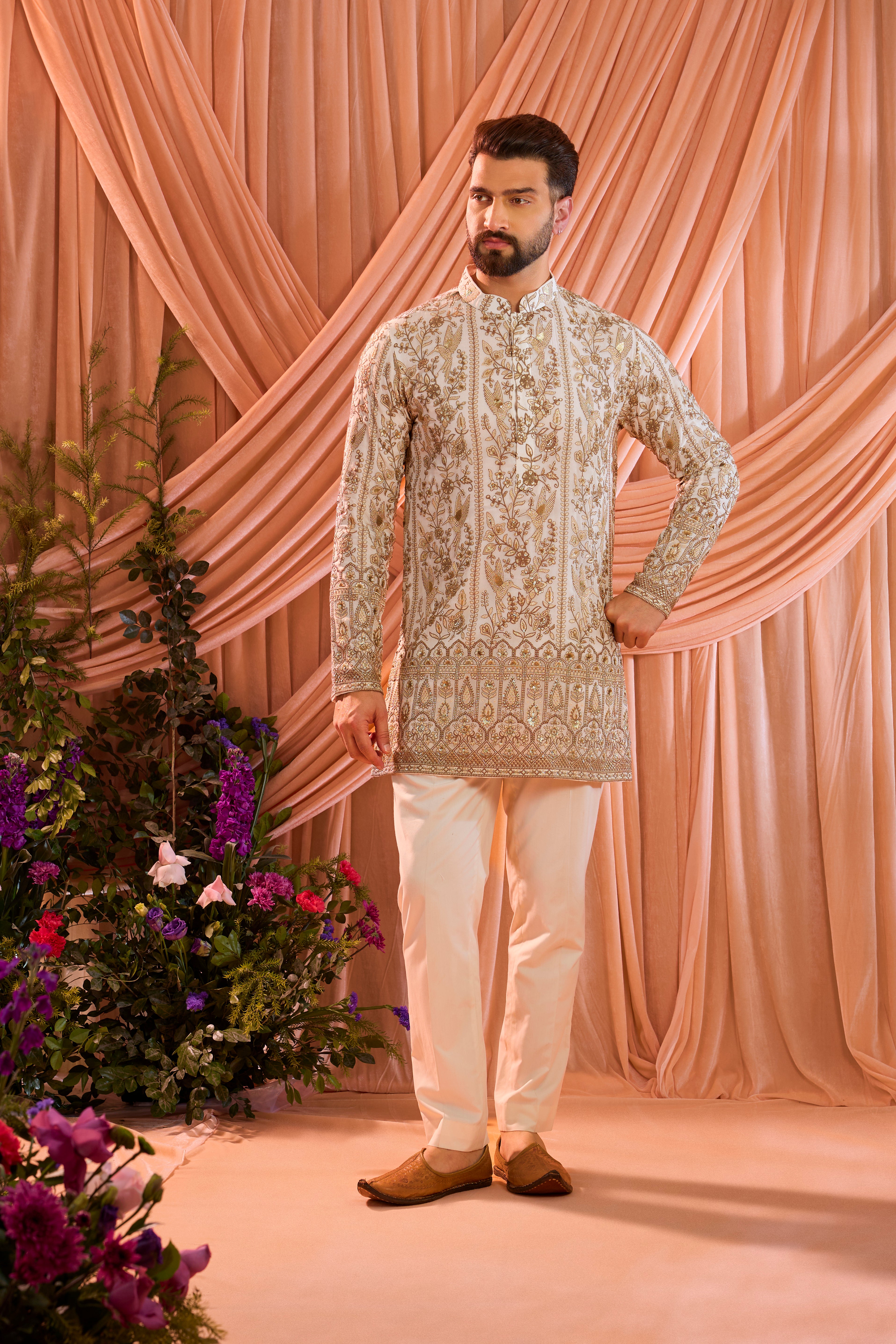 A  white short chikankari kurta adorned with intricate flora and fauna motifs, reflecting refined artisanal craftsmanship.