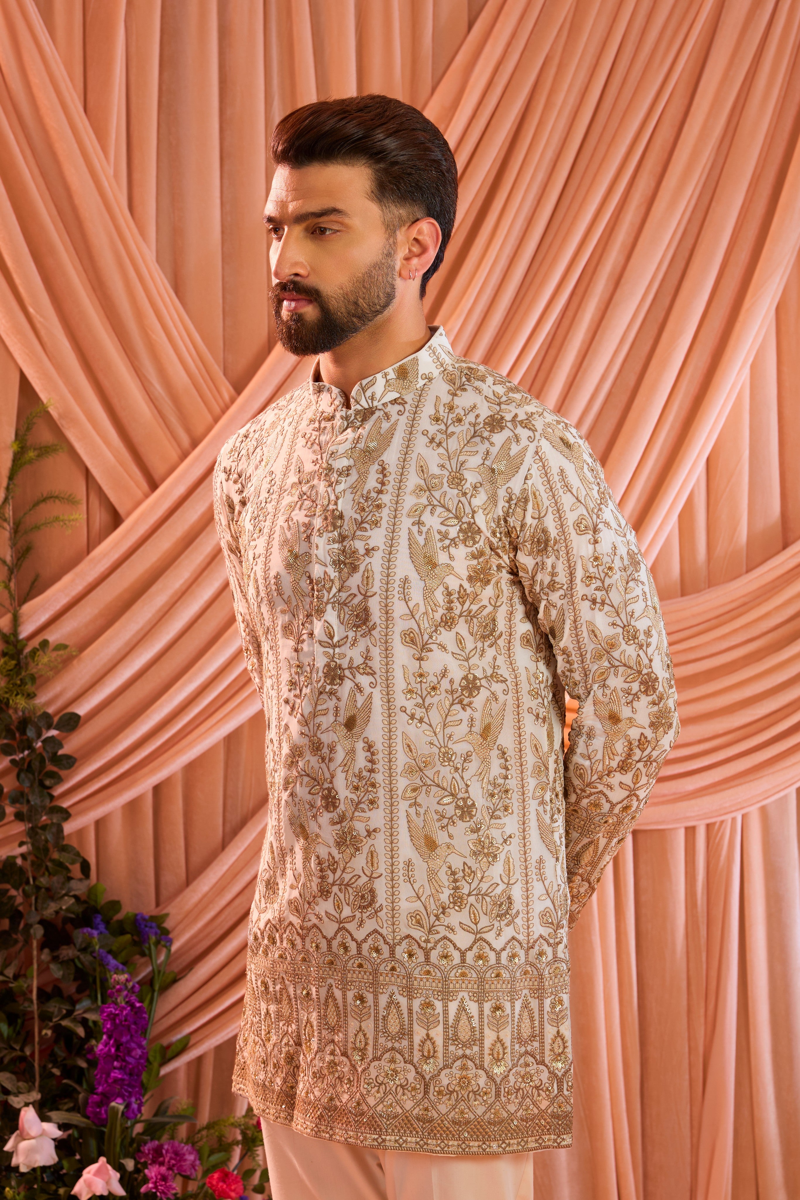A  white short chikankari kurta adorned with intricate flora and fauna motifs, reflecting refined artisanal craftsmanship.