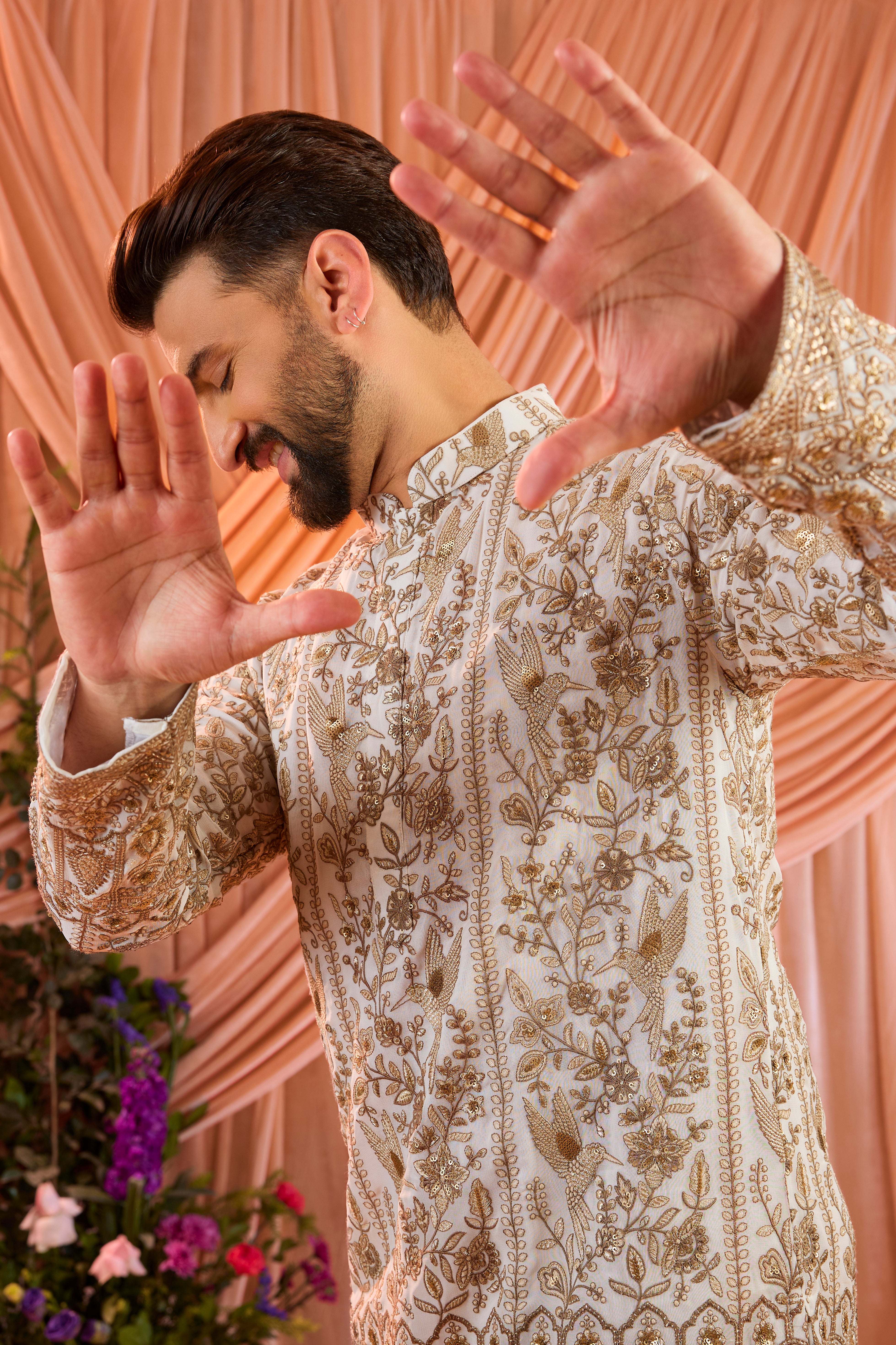 A  white short chikankari kurta adorned with intricate flora and fauna motifs, reflecting refined artisanal craftsmanship.
