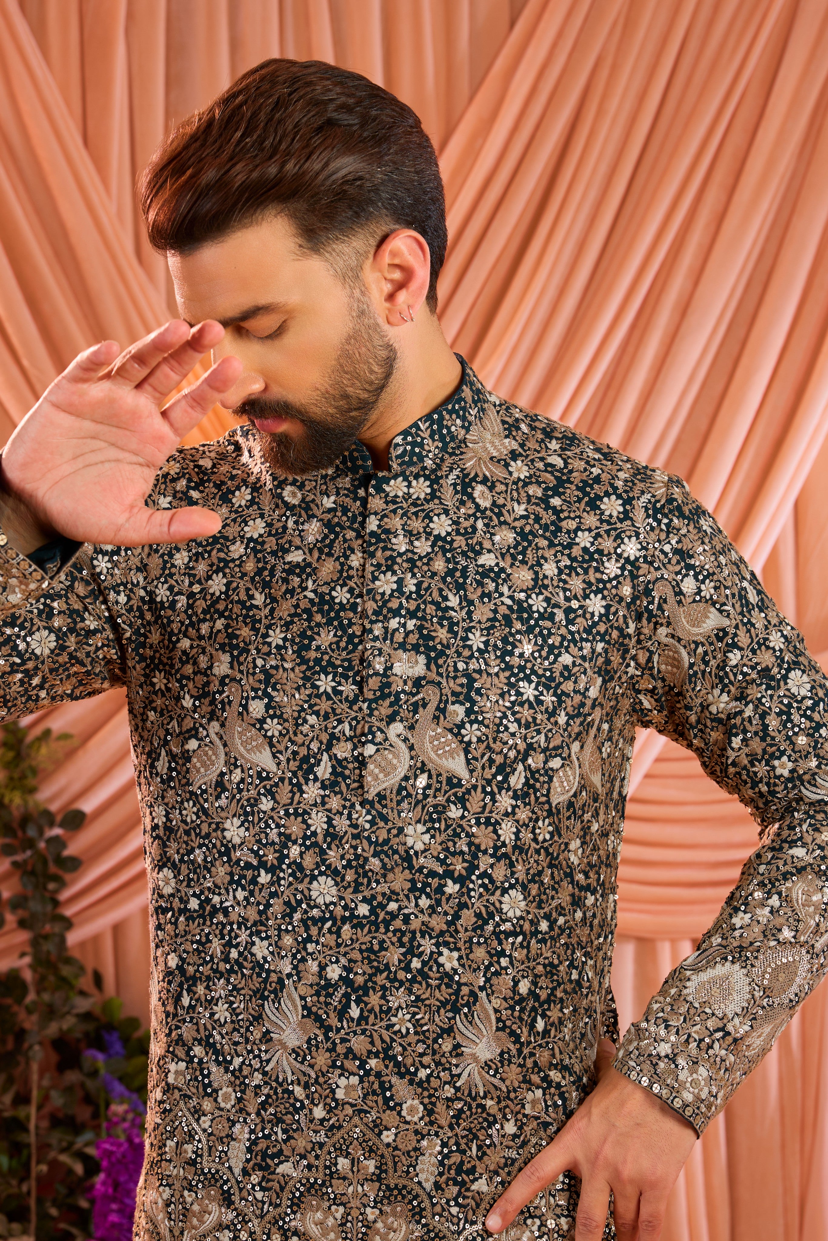 A teal short kurta adorned with intricate sequin embellishment, brought to life by detailed flora and fauna figures.