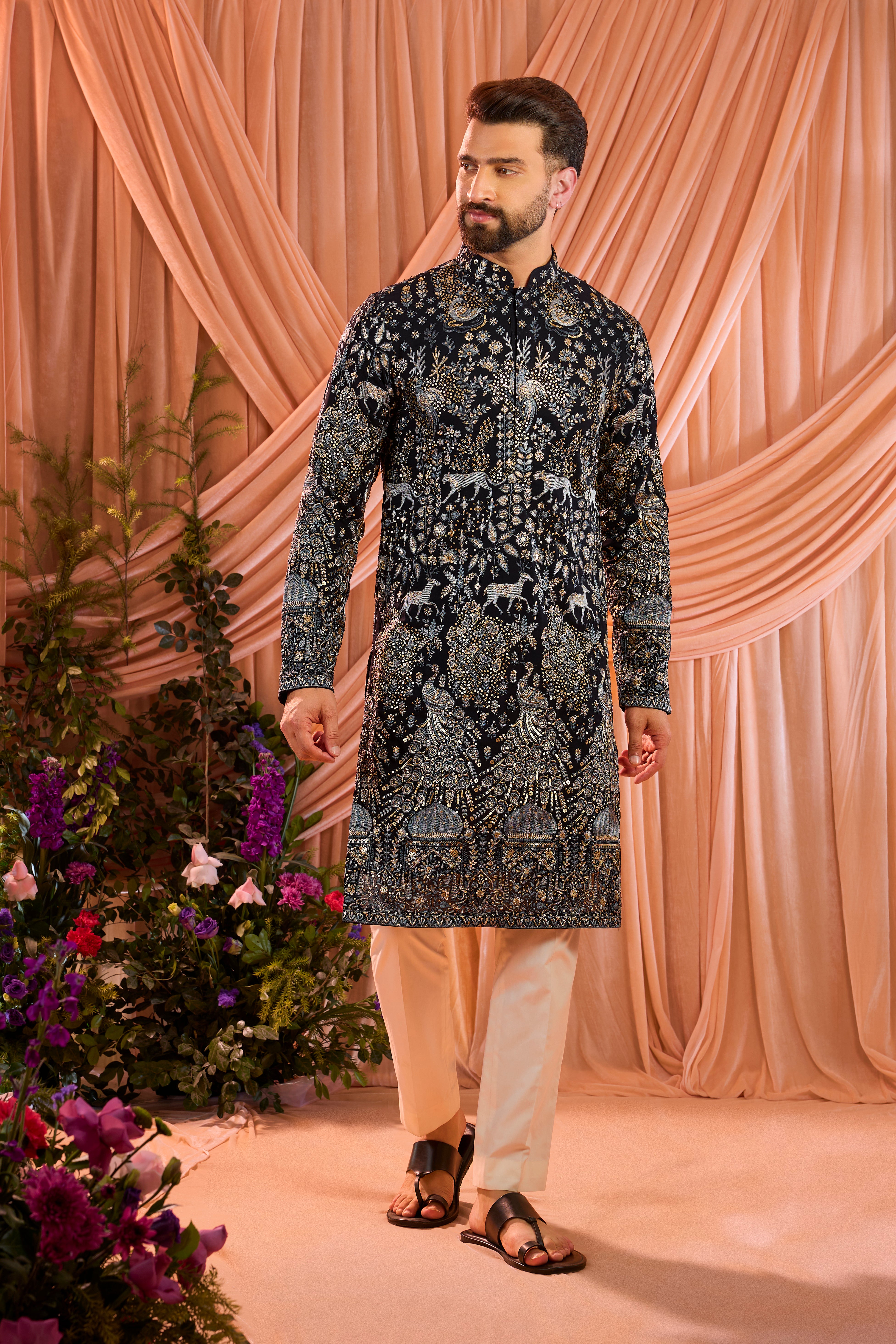 A blue royal heritage kurta adorned with detailed flora and fauna motifs and intricate darbar scenes.
