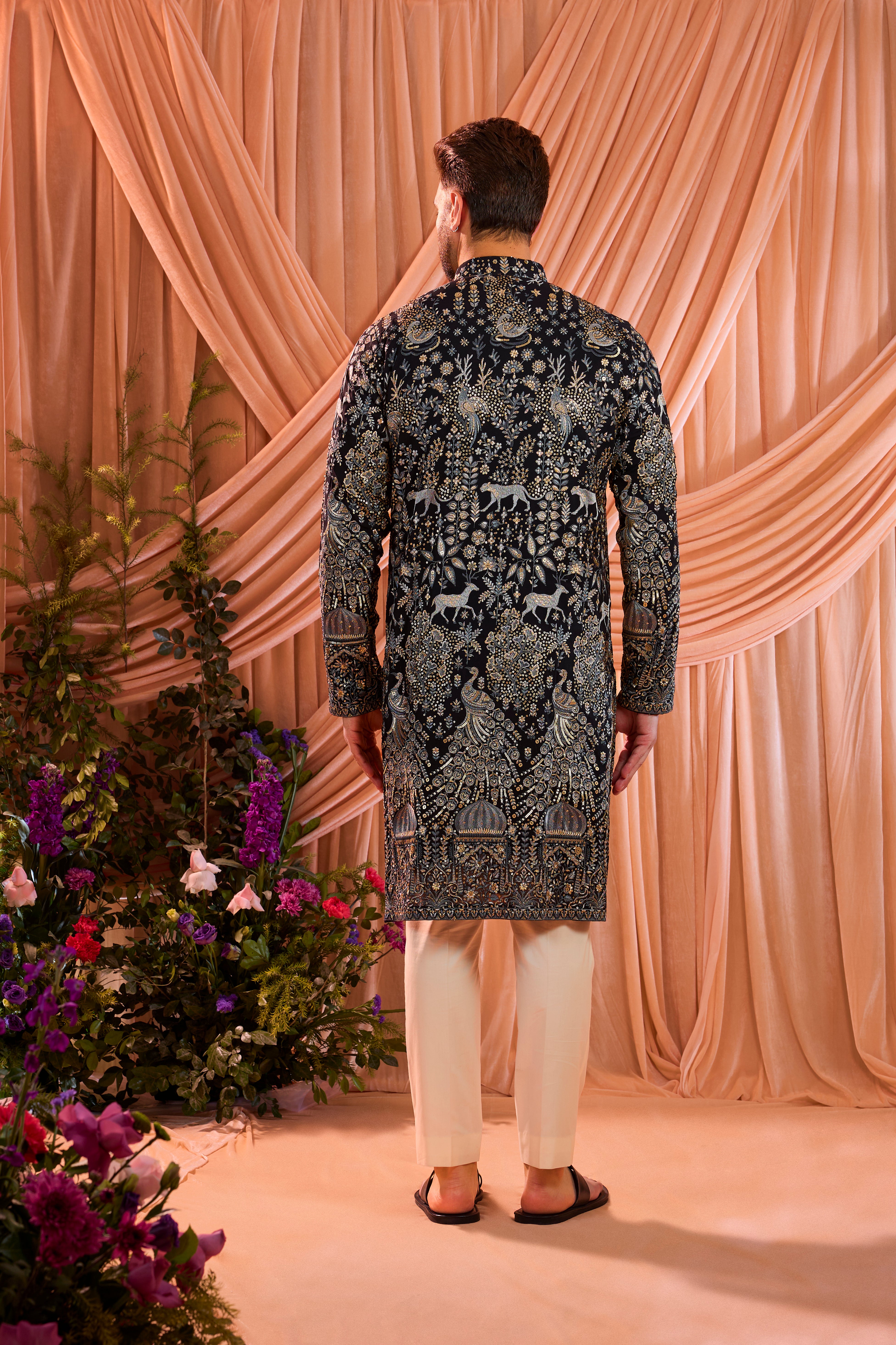 A blue royal heritage kurta adorned with detailed flora and fauna motifs and intricate darbar scenes.
