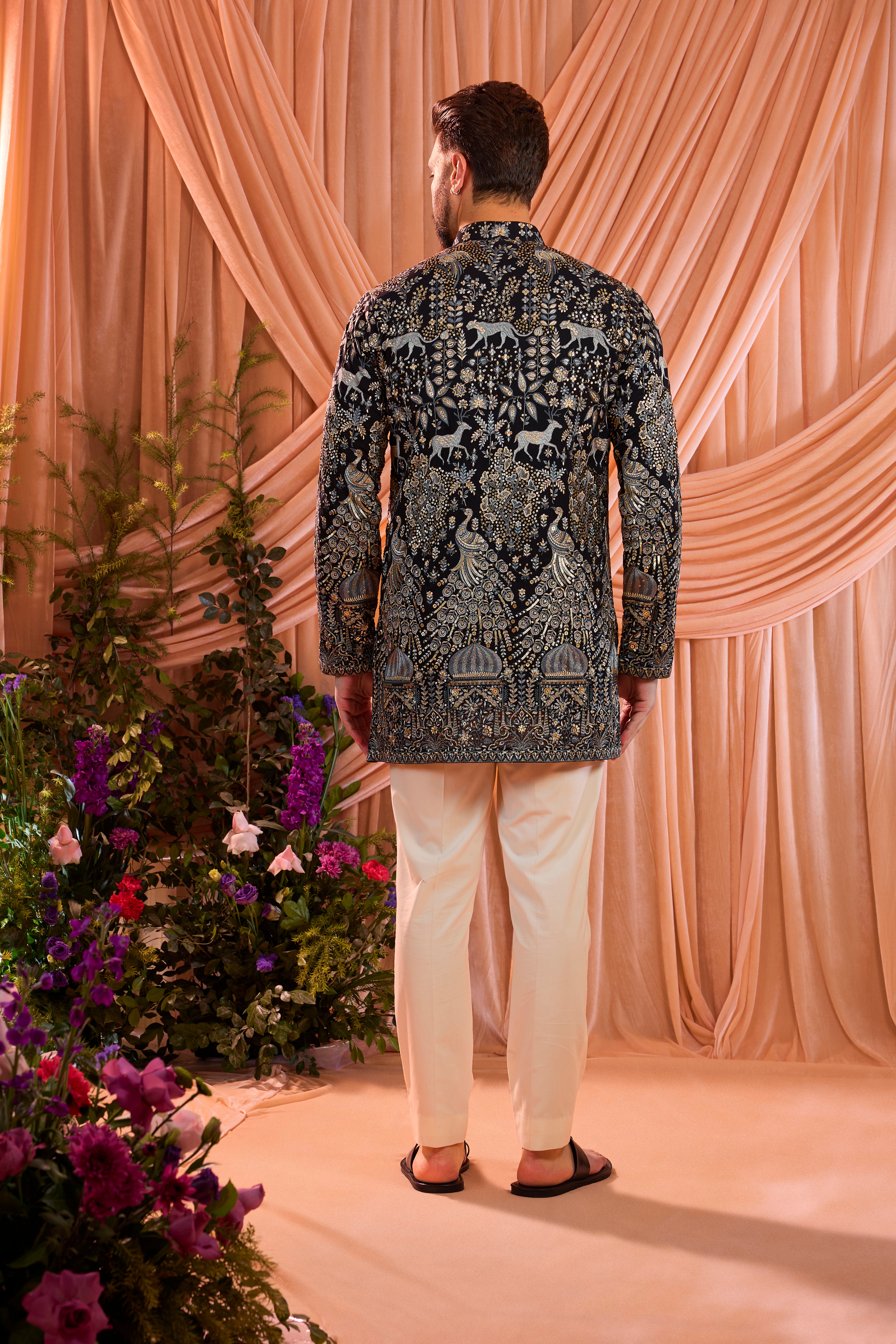 A blue royal heritage short kurta adorned with detailed flora and fauna motifs and intricate darbar scenes.