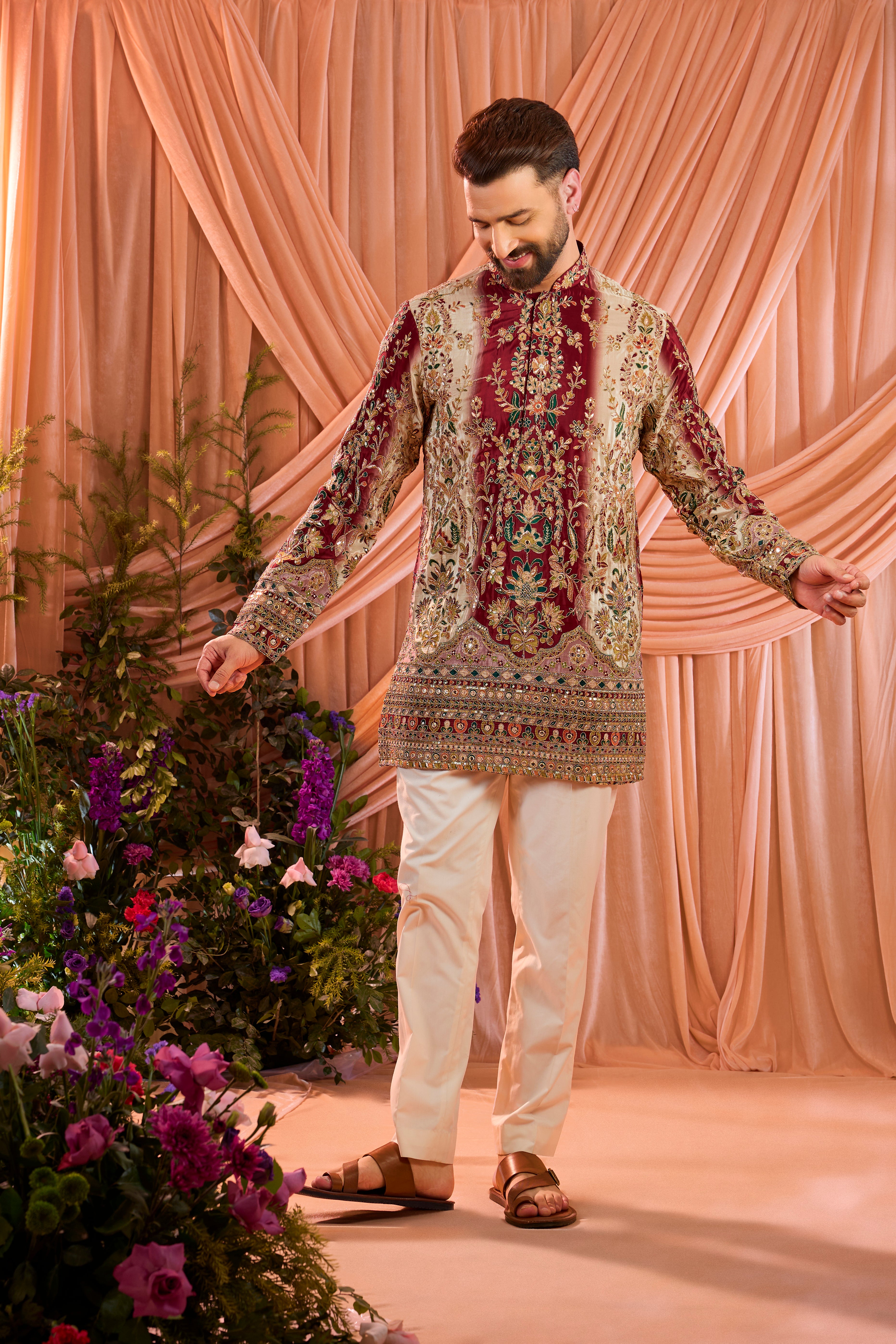 A green and gold short kurta adorned with detailed floral embroidery and shimmering sequin accents.