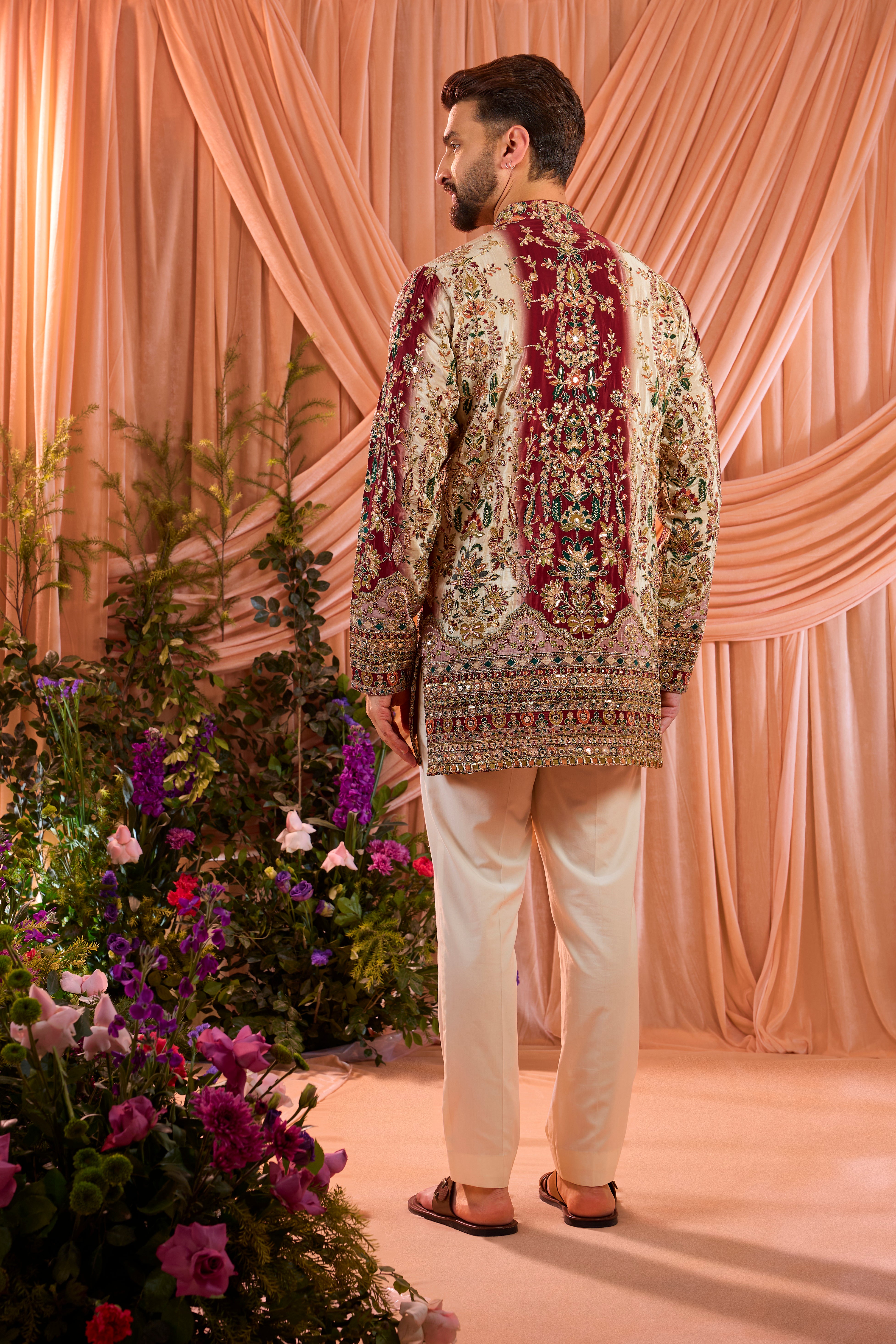 A green and gold short kurta adorned with detailed floral embroidery and shimmering sequin accents.