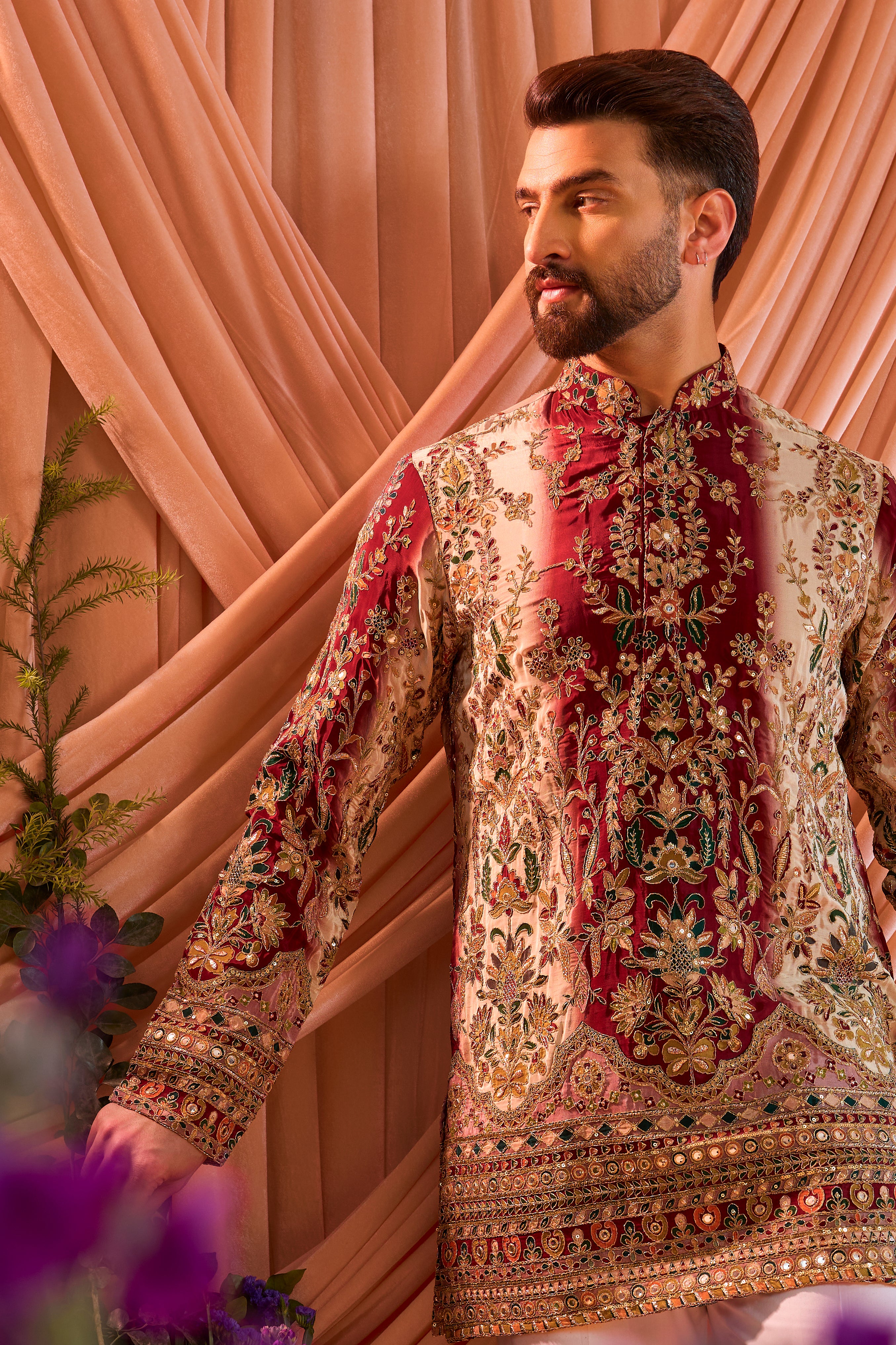 A green and gold short kurta adorned with detailed floral embroidery and shimmering sequin accents.