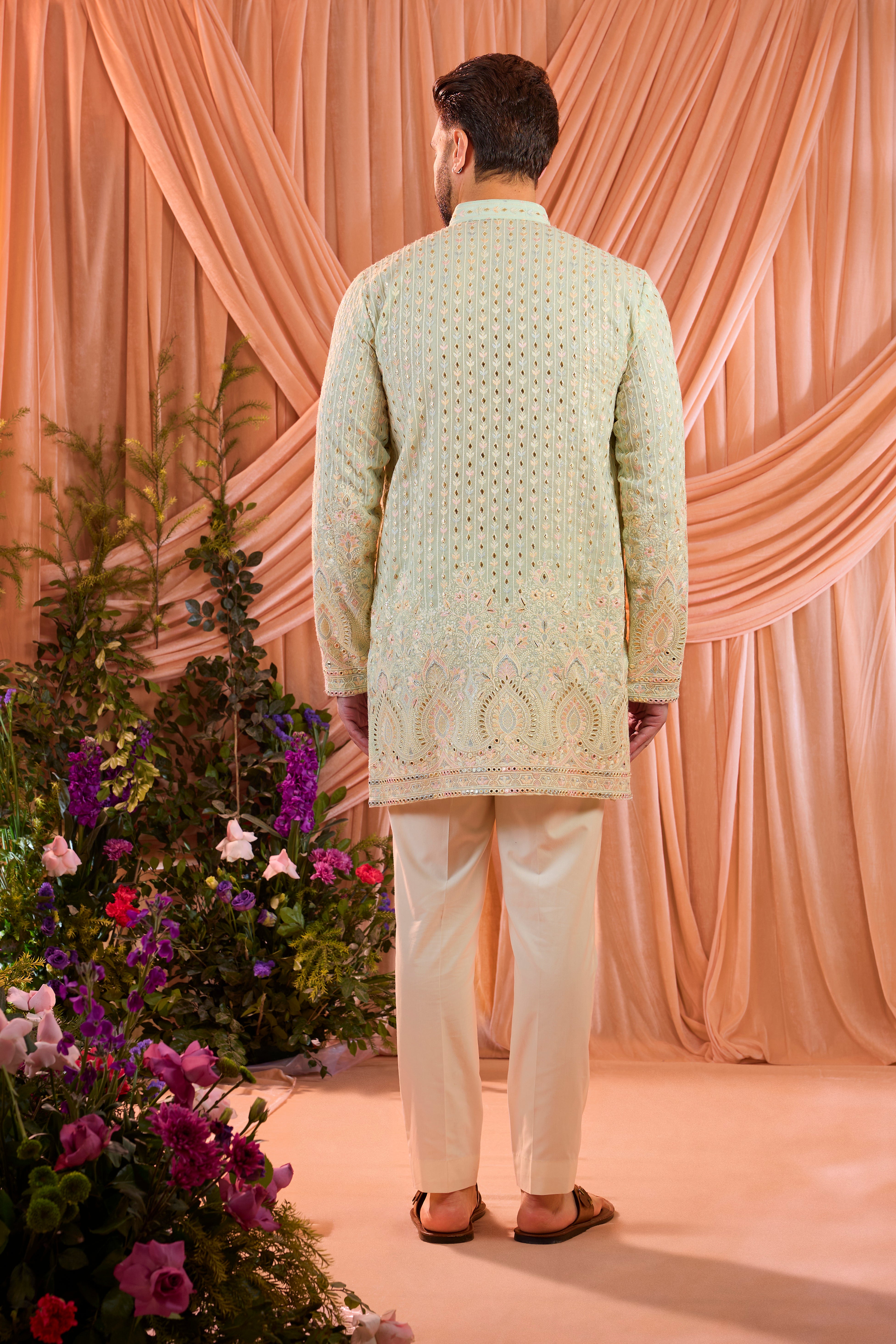 A aqua blue short kurta detailed with intricate multi-thread embroidery, enhanced by delicate sequins and subtle foil accents.