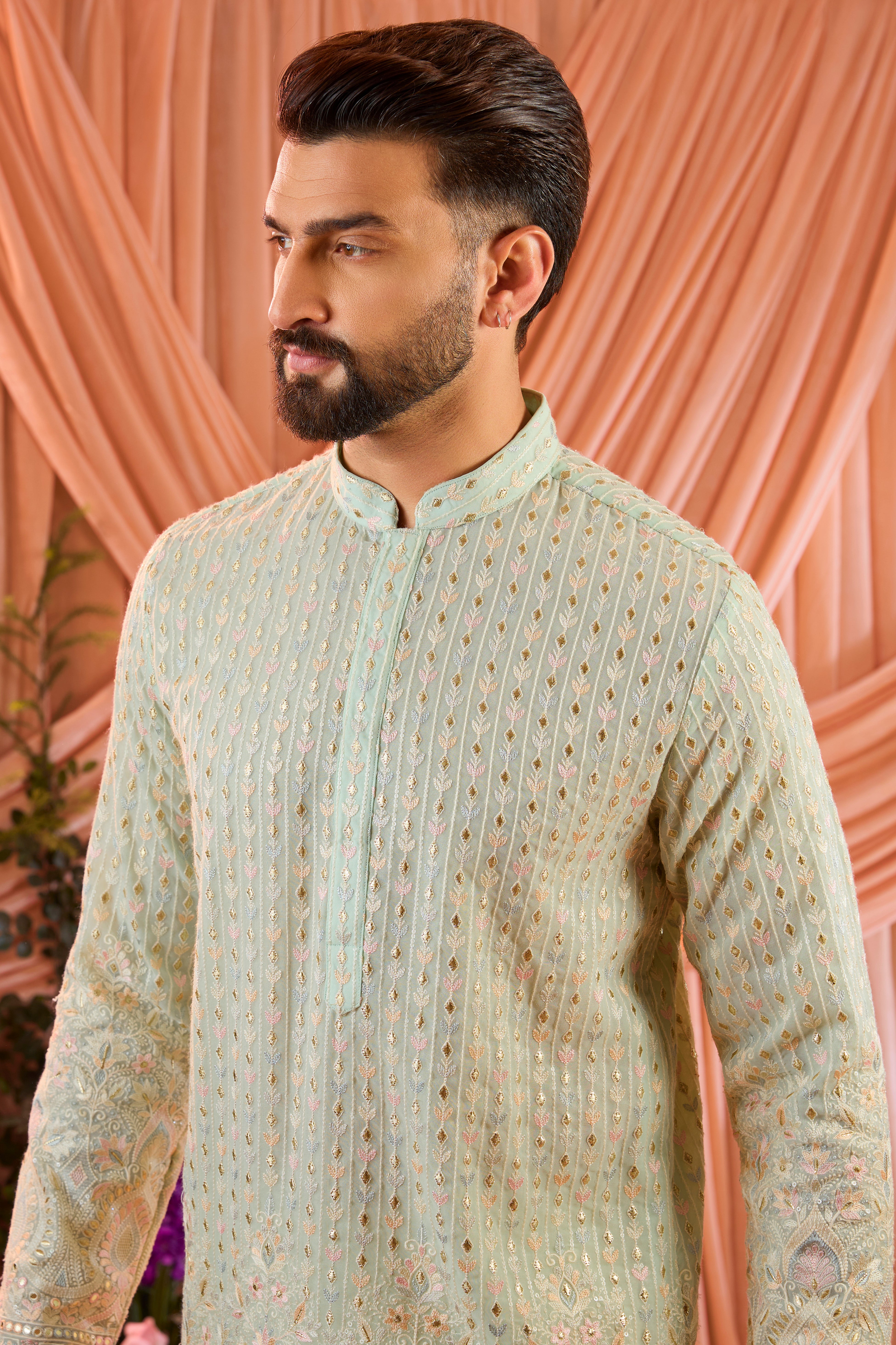 A aqua blue short kurta detailed with intricate multi-thread embroidery, enhanced by delicate sequins and subtle foil accents.