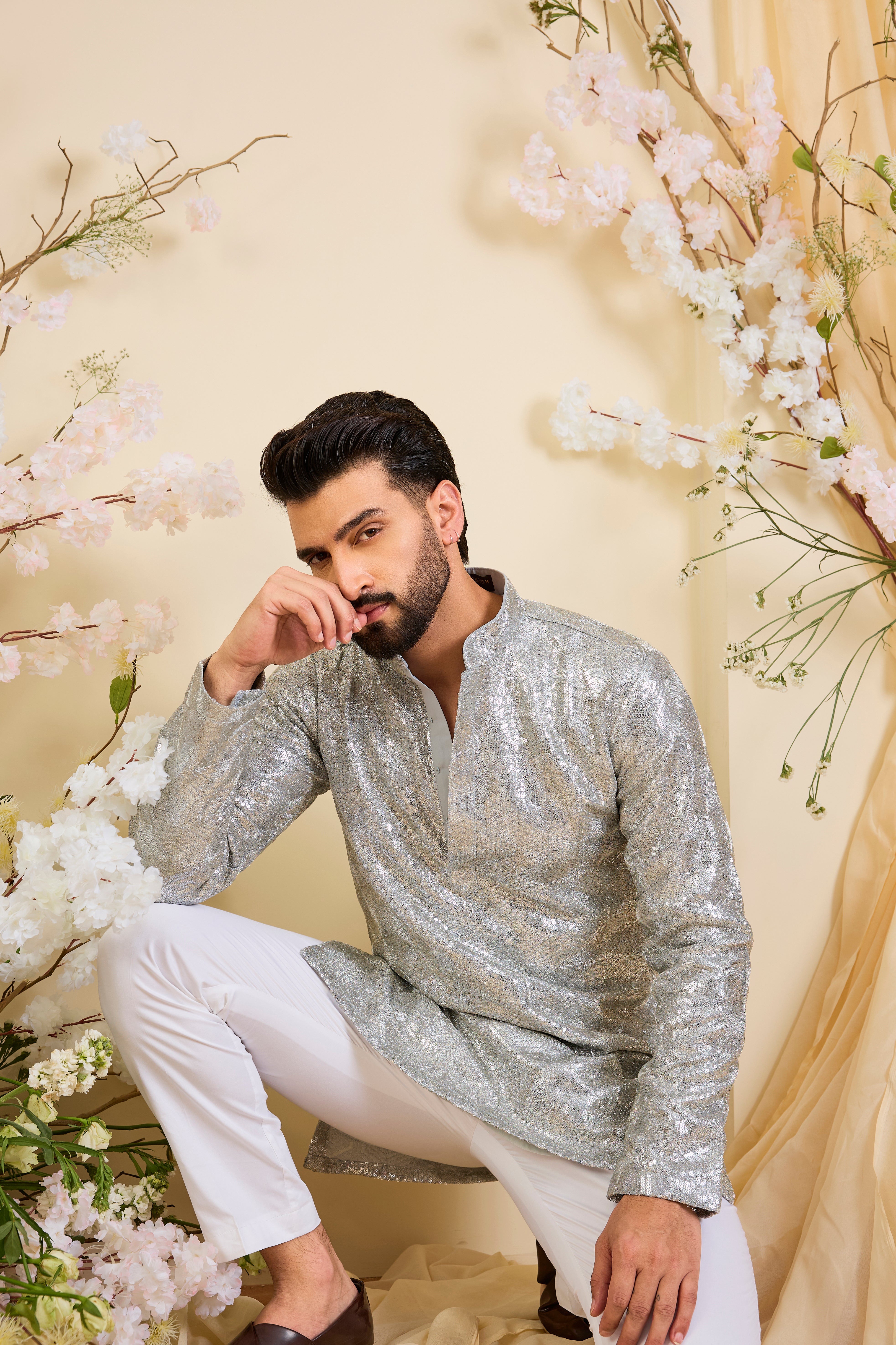 A luminous silver short kurta encrusted with dense, zari-like sequin work, delivering intense shine and intricate, high-impact detailing. Made to stand out.