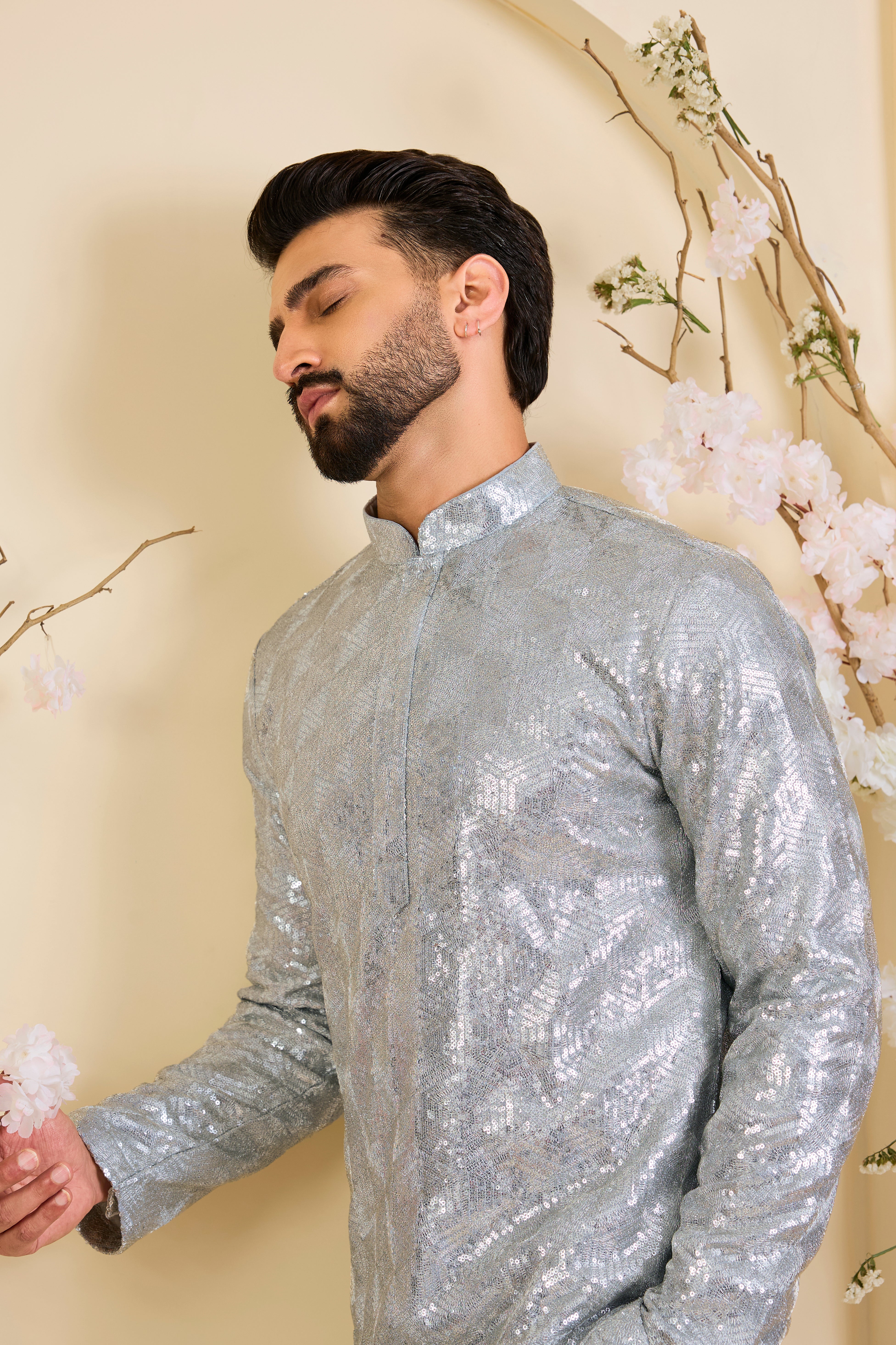 A luminous silver short kurta encrusted with dense, zari-like sequin work, delivering intense shine and intricate, high-impact detailing. Made to stand out.