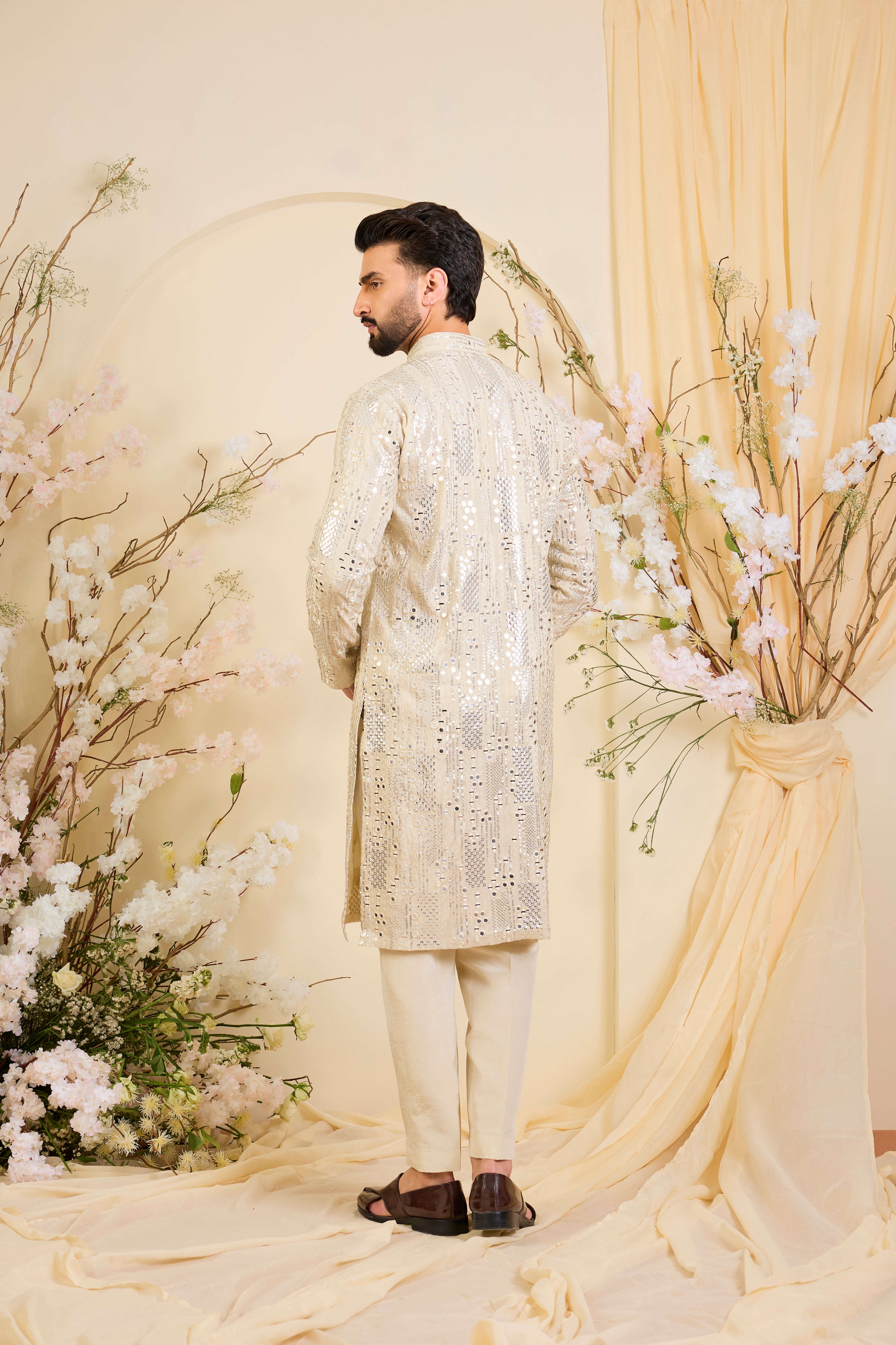 Golden tissue long kurta with intricate sequin mirrorwork and tone-on-tone threadwork. A luminous take on understated opulence.