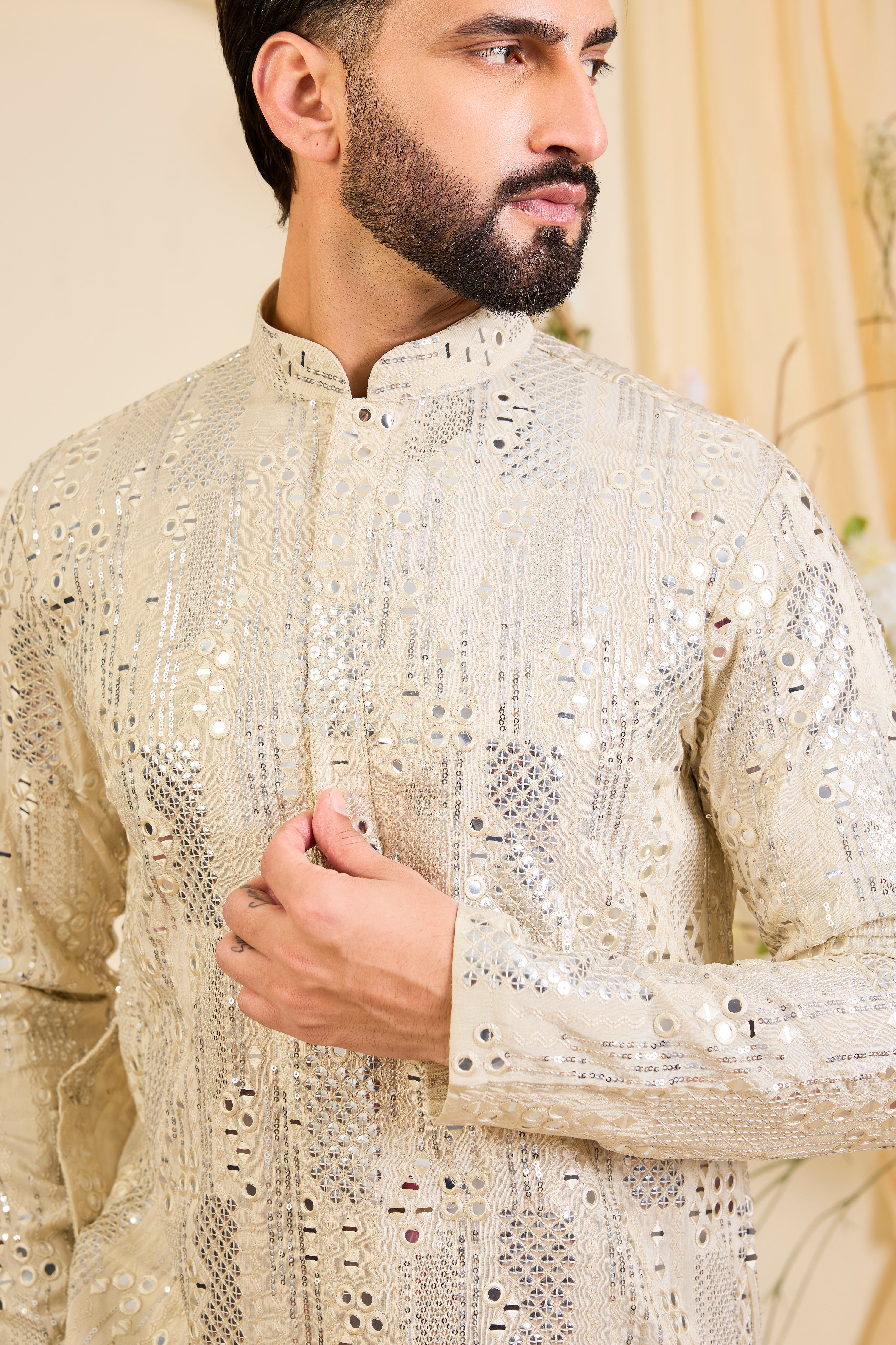 Golden tissue long kurta with intricate sequin mirrorwork and tone-on-tone threadwork. A luminous take on understated opulence.