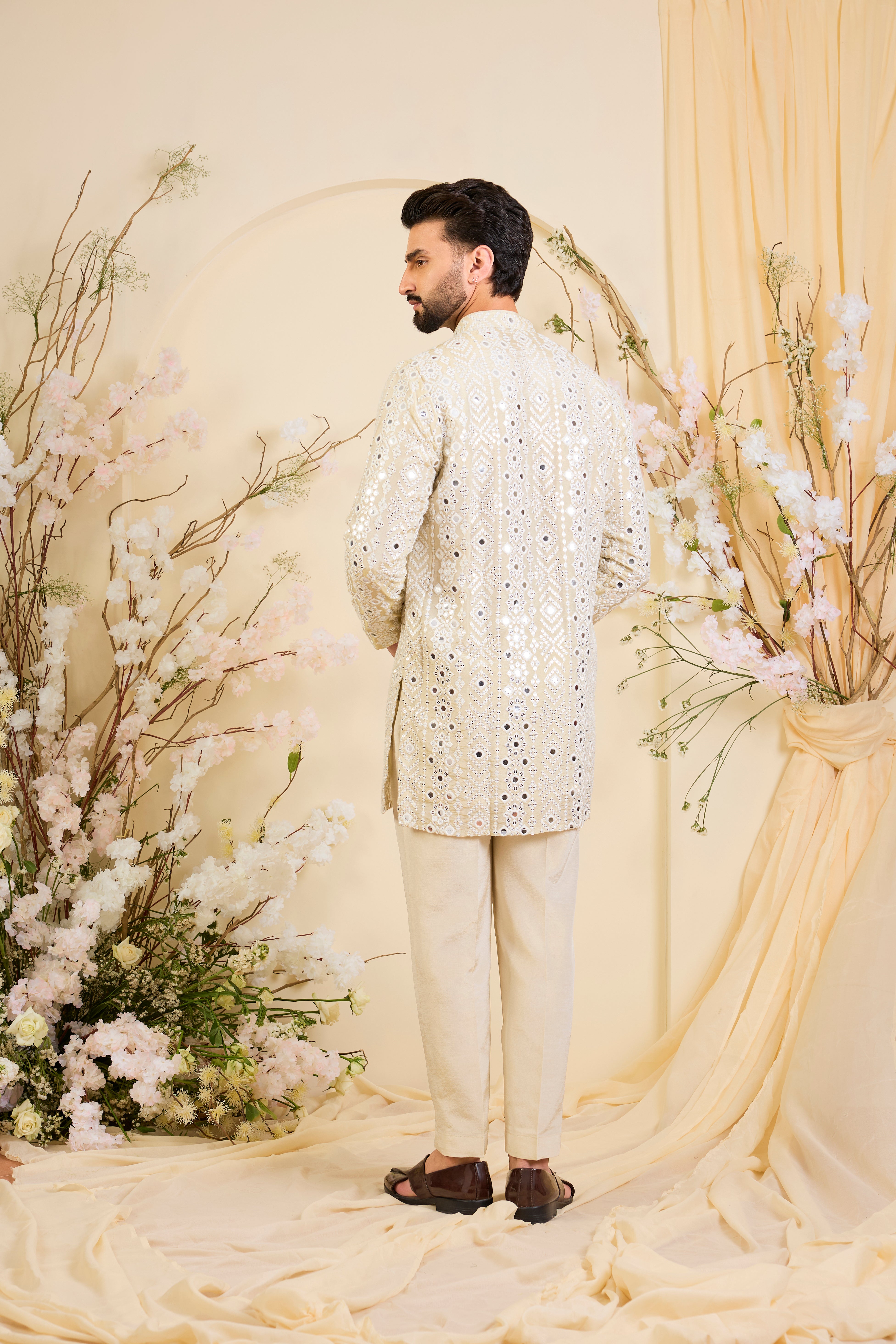 Golden tissue short kurta with intricate sequin mirrorwork and tone-on-tone threadwork. A luminous take on understated opulence.