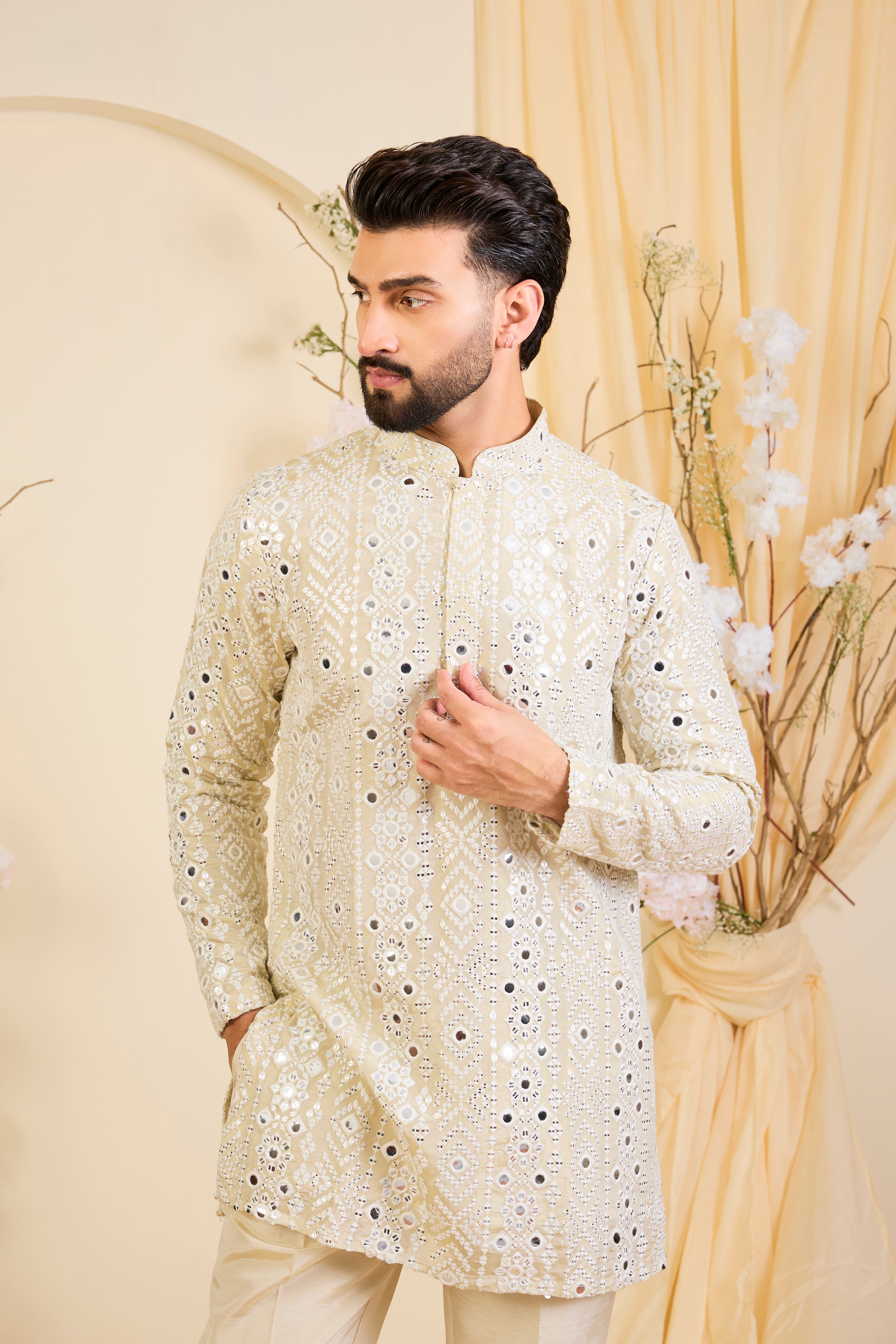 Golden tissue short kurta with intricate sequin mirrorwork and tone-on-tone threadwork. A luminous take on understated opulence.