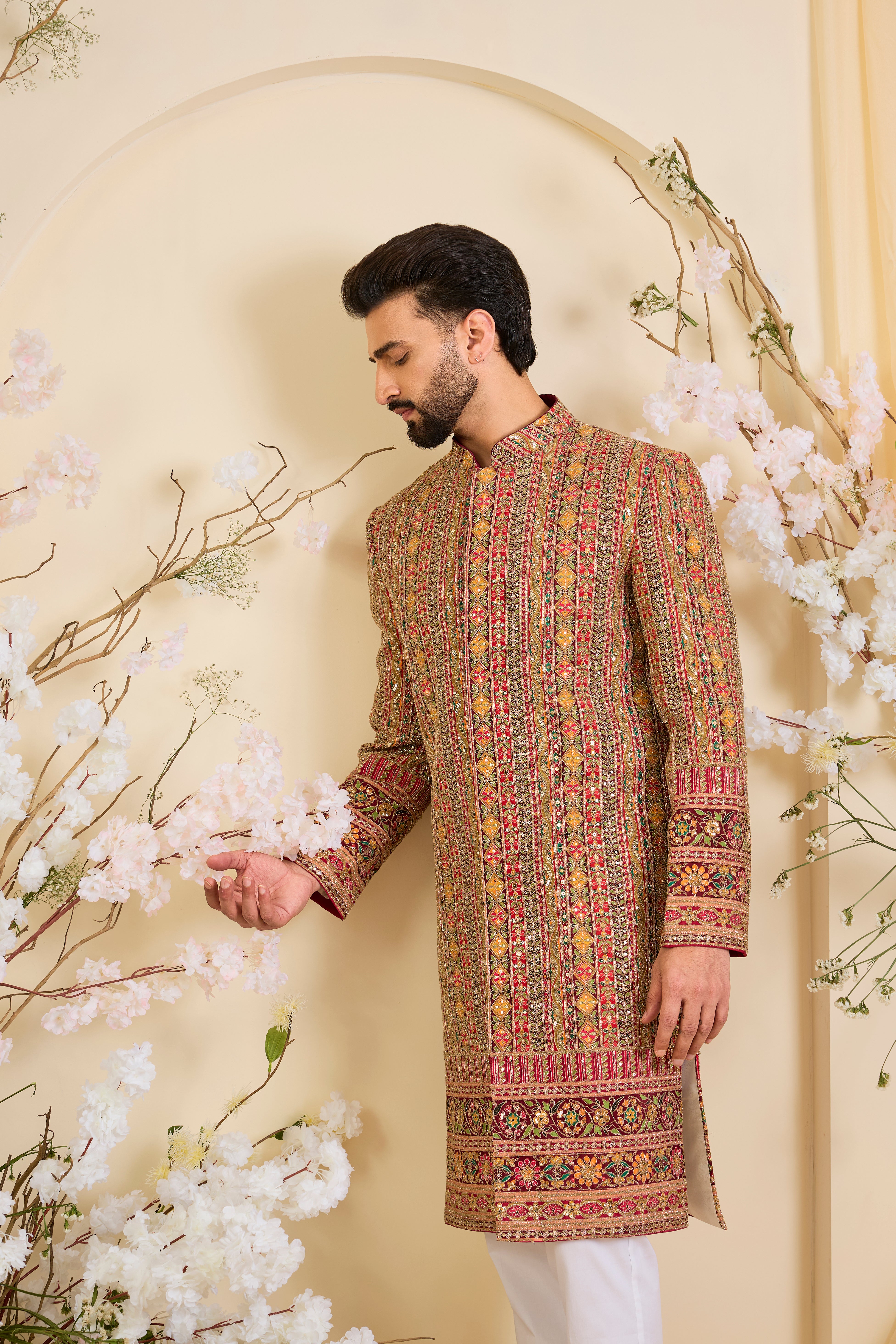 Pink base sherwani with heavy zari embroidery, intricate sequins, and multicolour prints, crafted for bold, opulent, statement-making occasions.