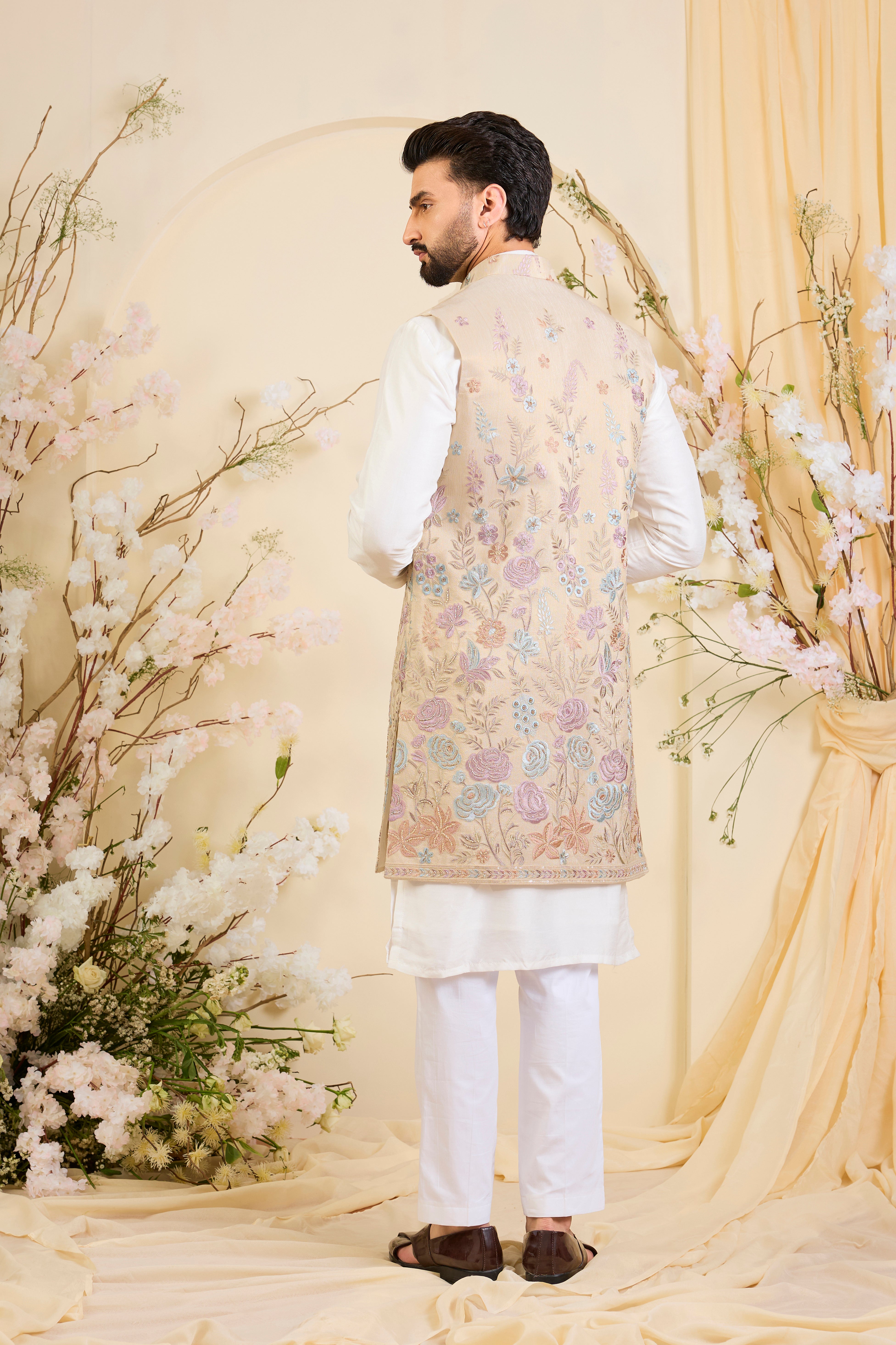 Beige-gold long open jacket with intricate multicolour floral embroidery and delicate cut dana work, offering a refined, luminous couture statement.