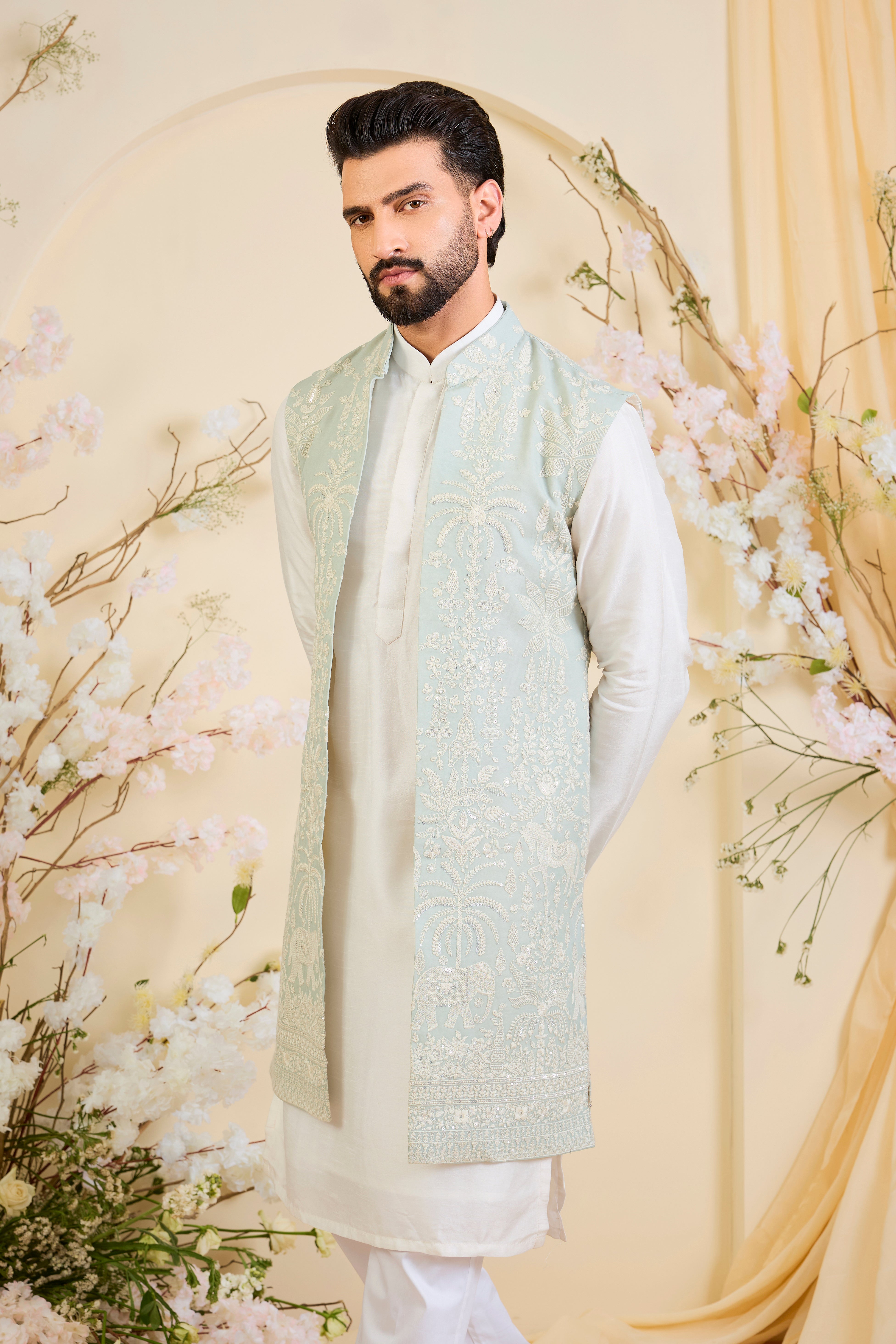 Blue sequined long jacket with ivory threadwork and intricate flora-fauna embroidery, crafted for luminous, refined, statement-making elegance.