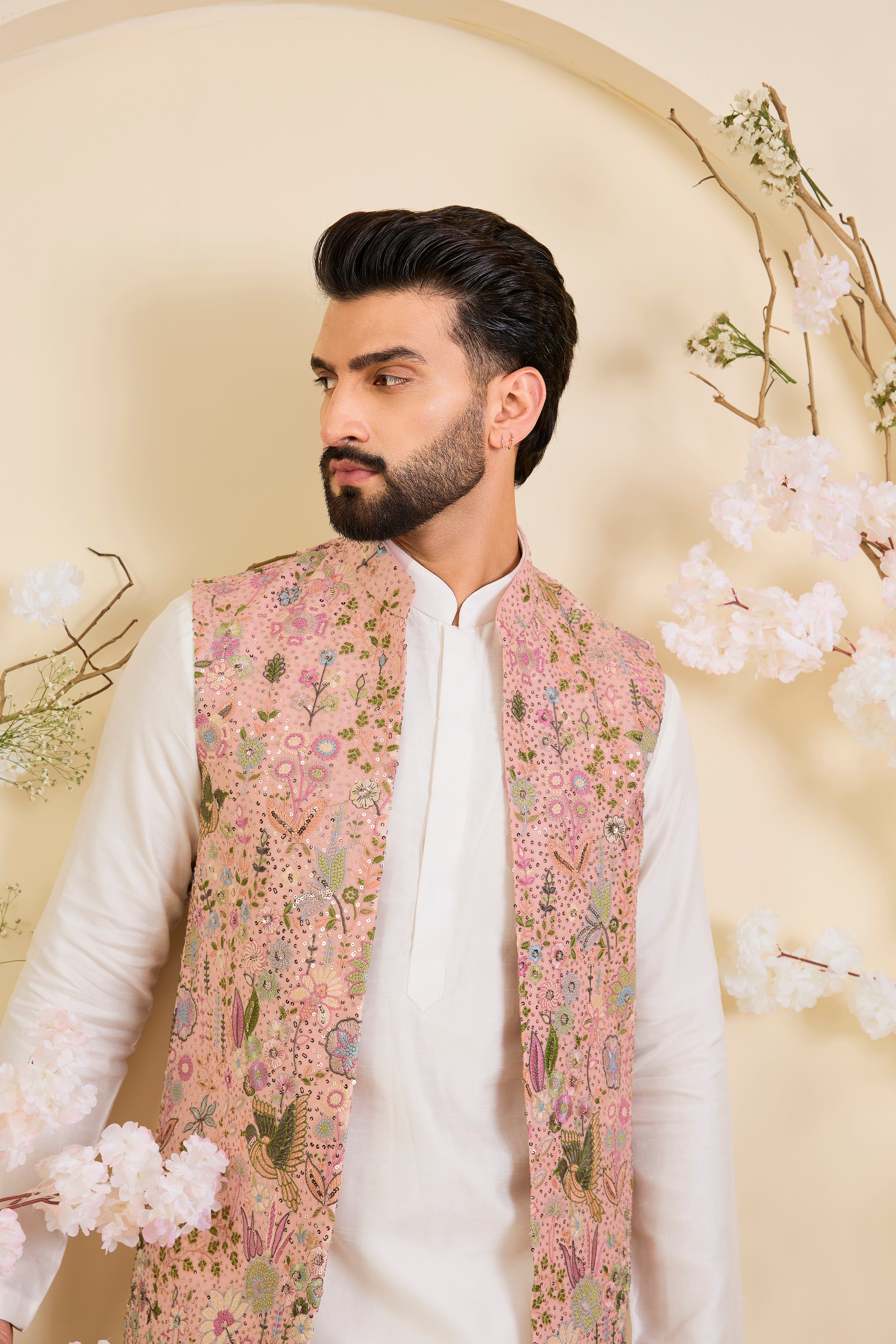 Pink long open jacket with intricate sequin work and detailed flora-fauna motifs, offering a luminous, richly layered couture statement.