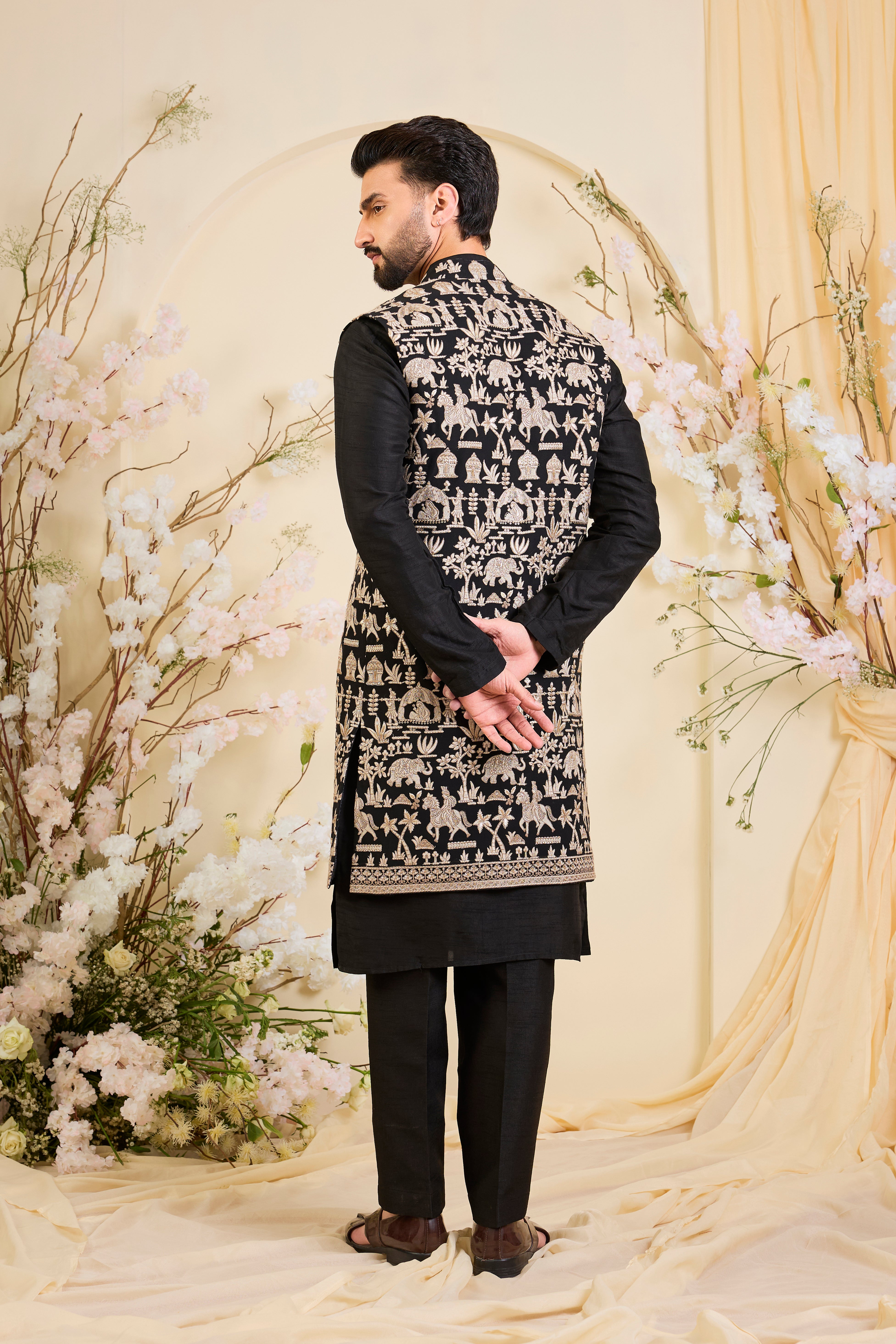 Black long open jacket with intricate zari work, sequin detailing, and Mughal-era embroidery, delivering a richly layered, regal couture statement.