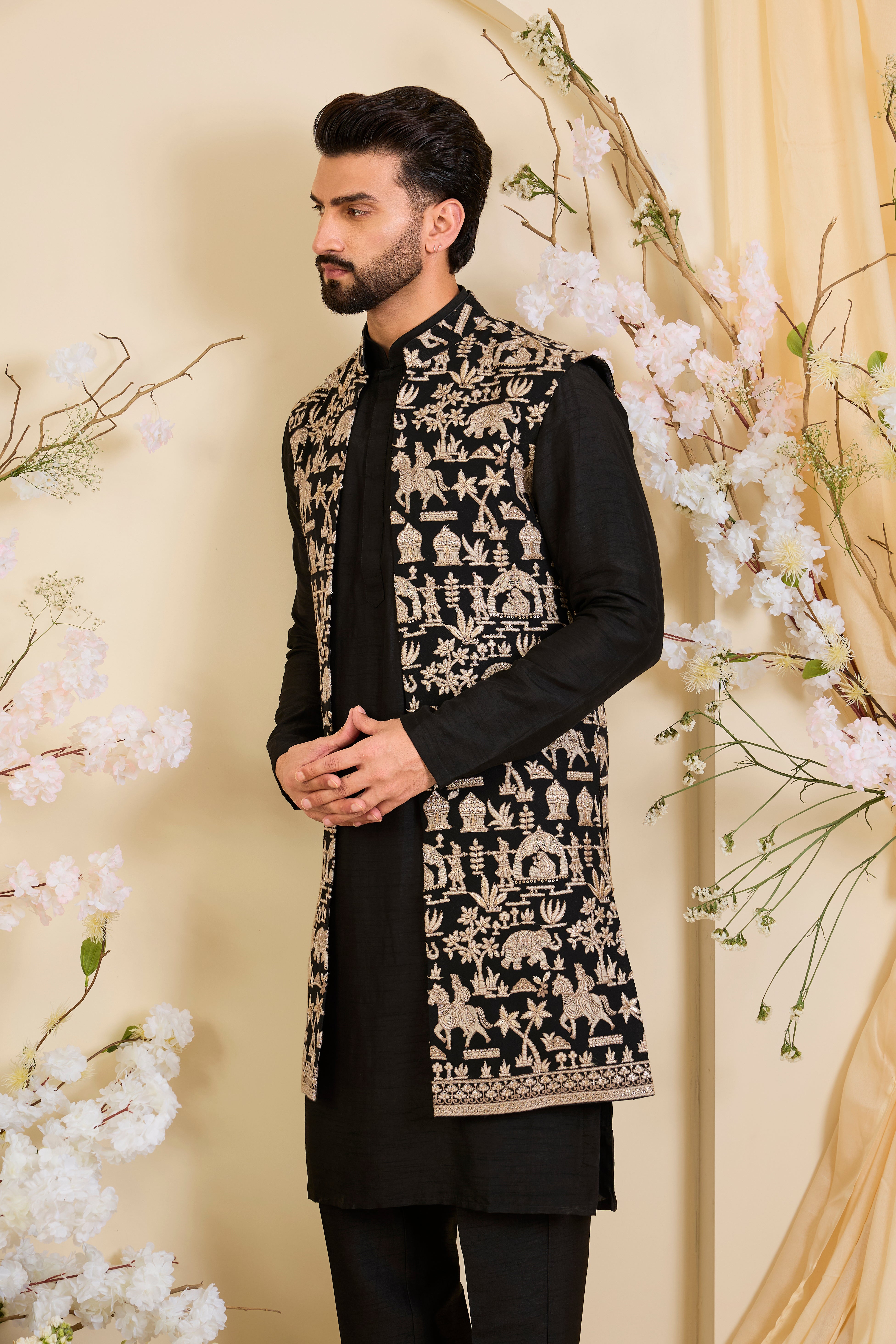 Black long open jacket with intricate zari work, sequin detailing, and Mughal-era embroidery, delivering a richly layered, regal couture statement.