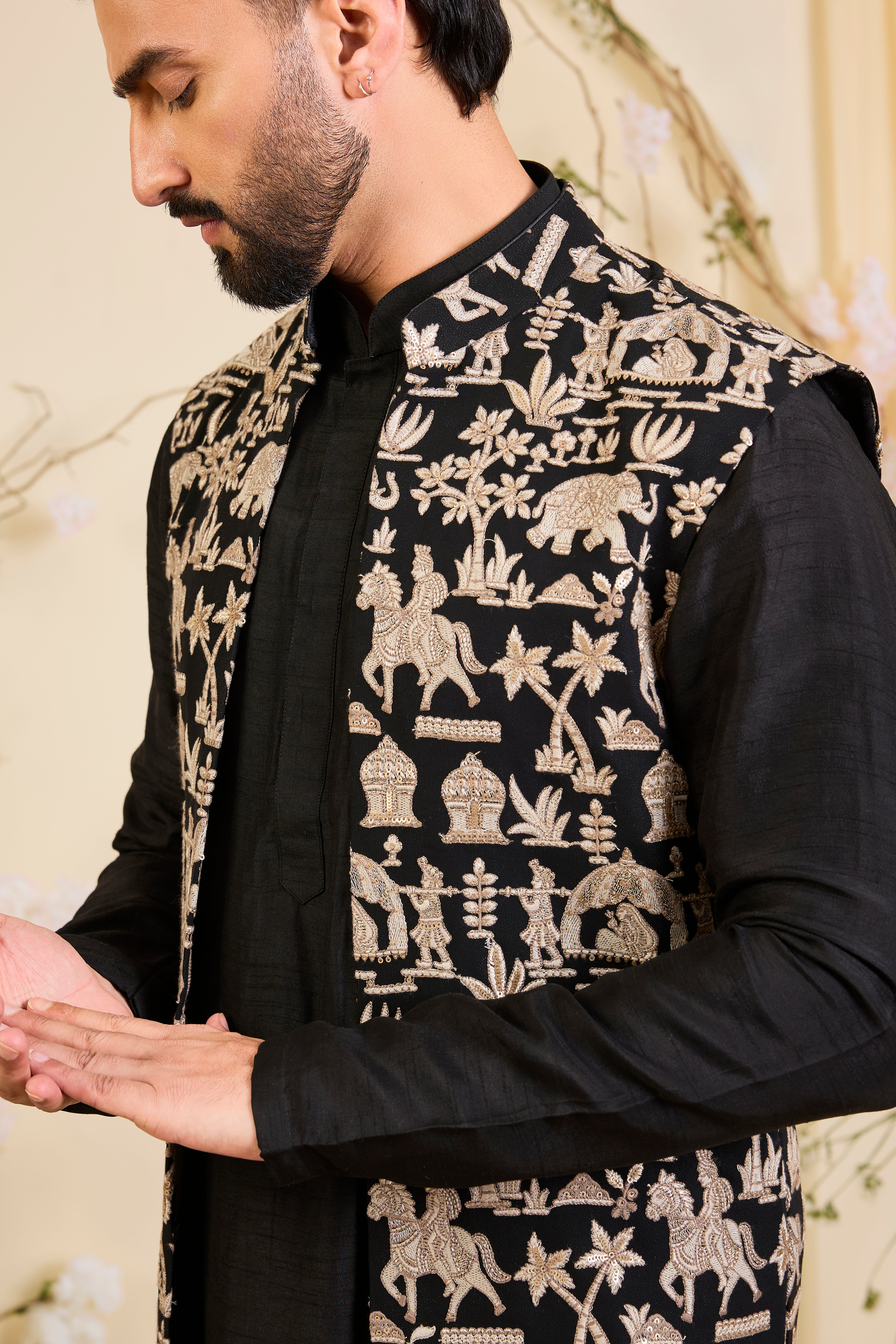 Black long open jacket with intricate zari work, sequin detailing, and Mughal-era embroidery, delivering a richly layered, regal couture statement.