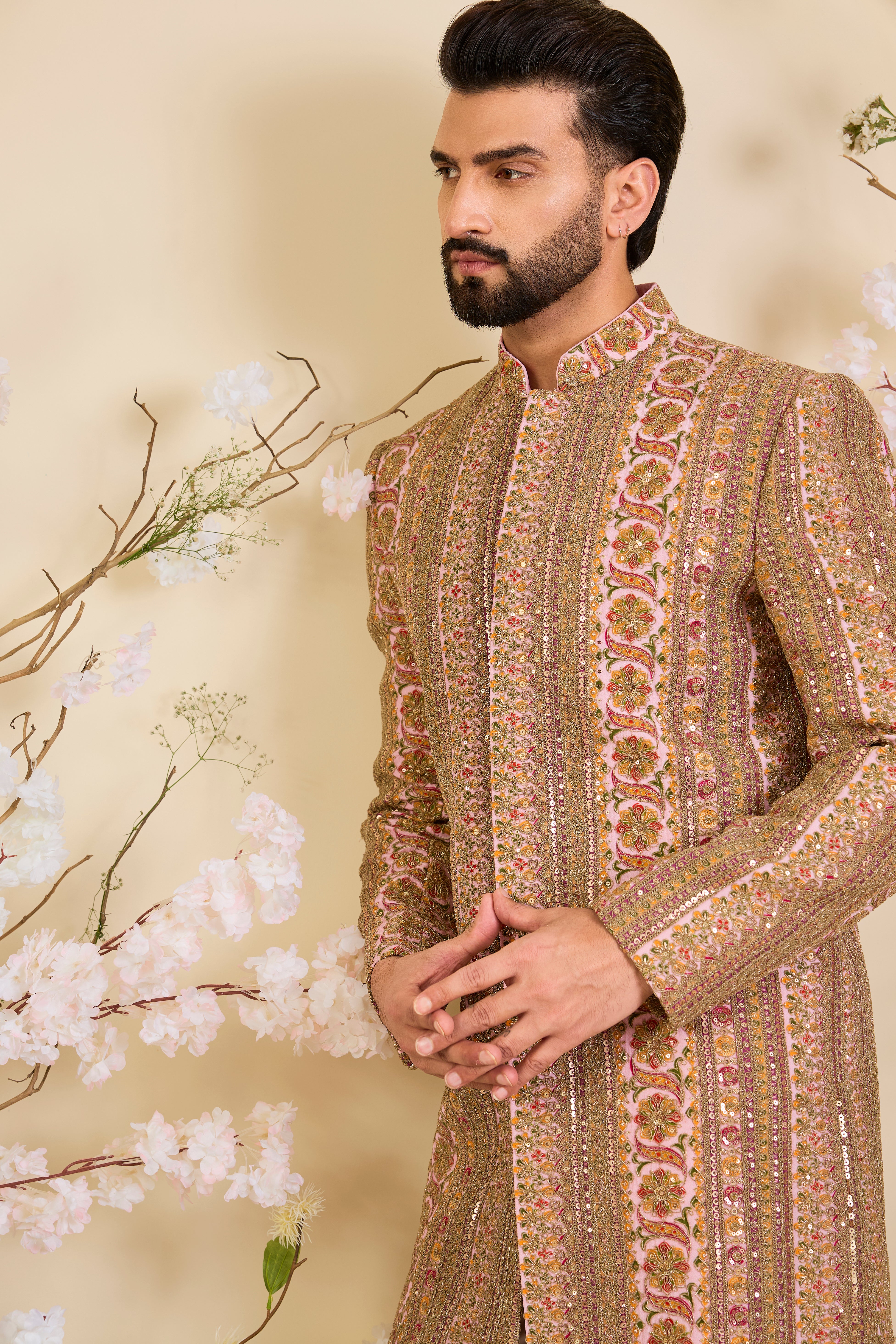 Pink base sherwani with heavy zari embroidery, intricate sequins, and multicolour prints, crafted for bold, opulent, statement-making occasions.