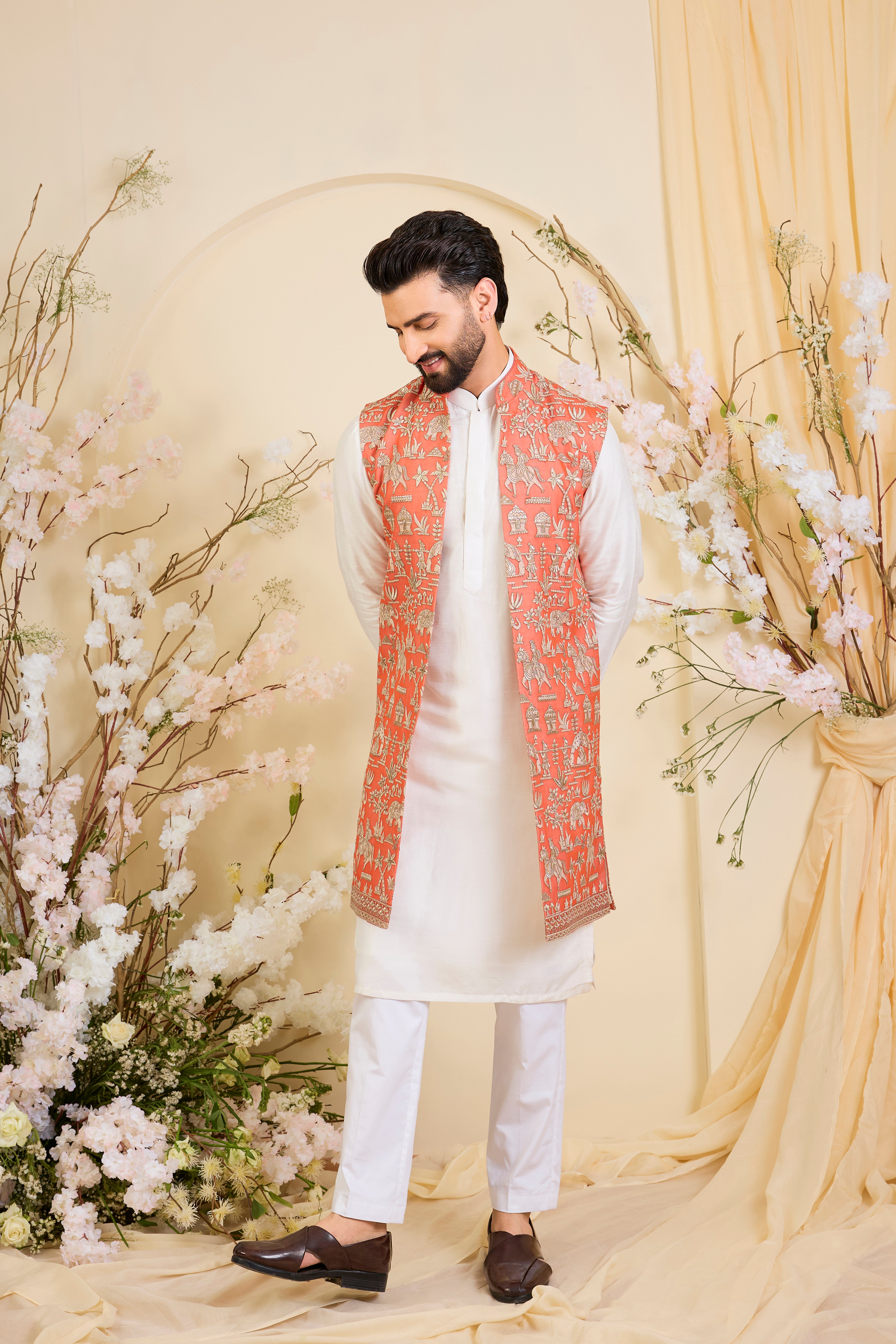 Orange long open jacket with intricate zari work, sequin detailing, and Mughal-era embroidery, delivering a richly layered, regal couture statement.