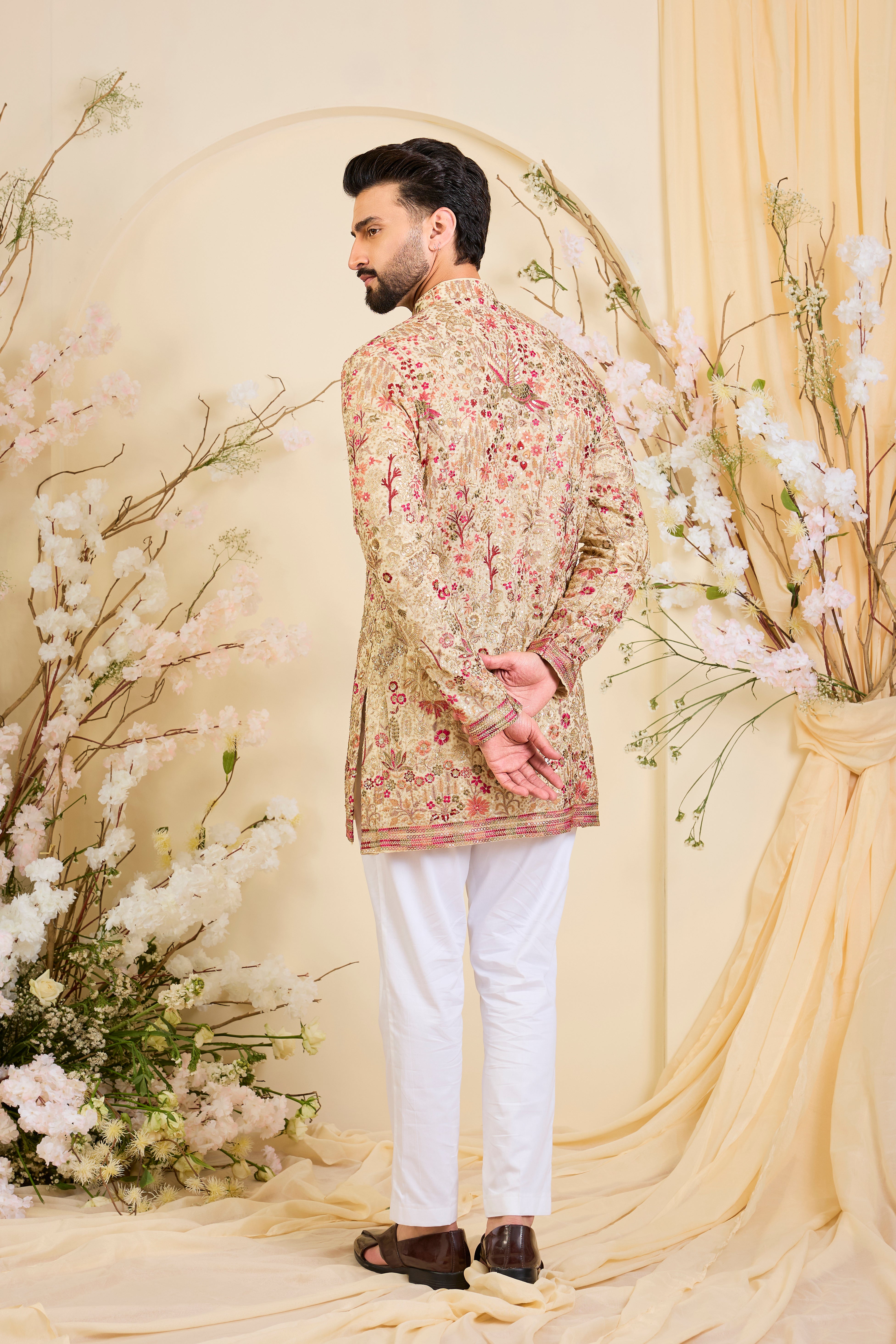 Golden-cream kurta with multicolour threadwork, zari, and sequins, creating a magical flora-fauna canvas with luminous, dreamlike elegance.